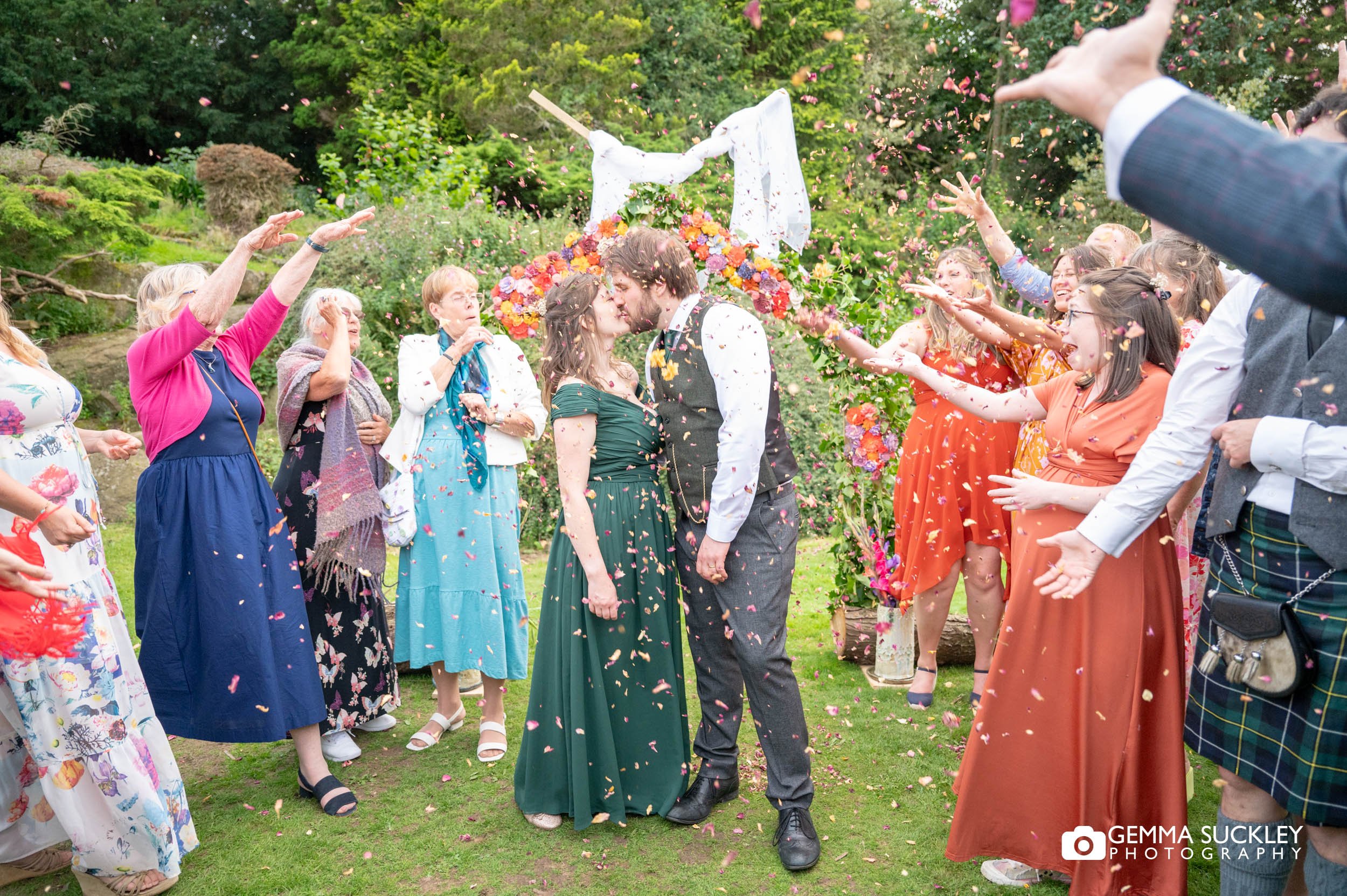 wedding guests throwing confetti at the married couple