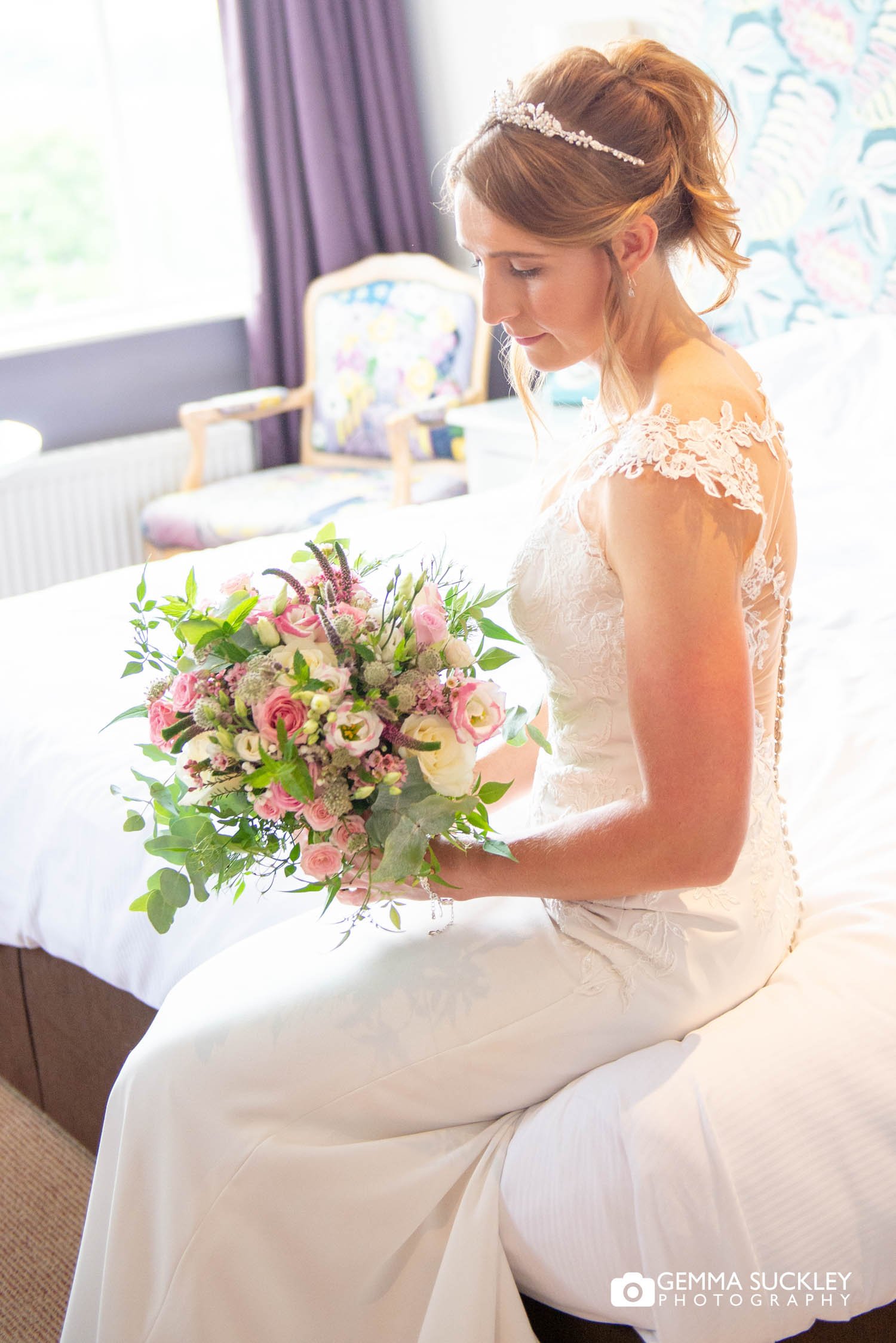 a bride sitting on the bed in her wedding dress