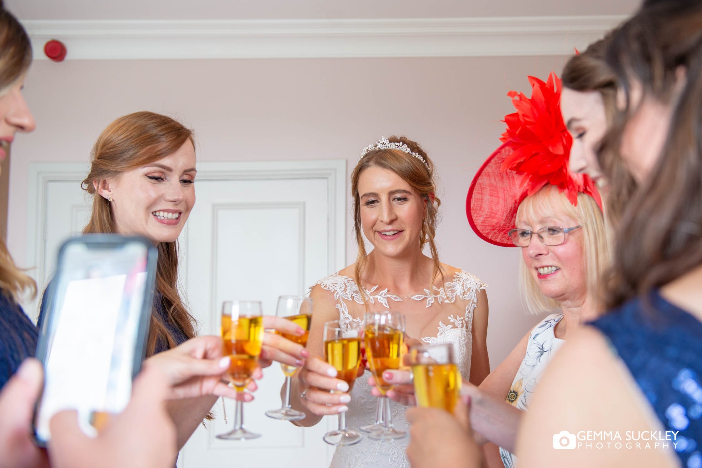 bridal party drinking champagne while getting ready