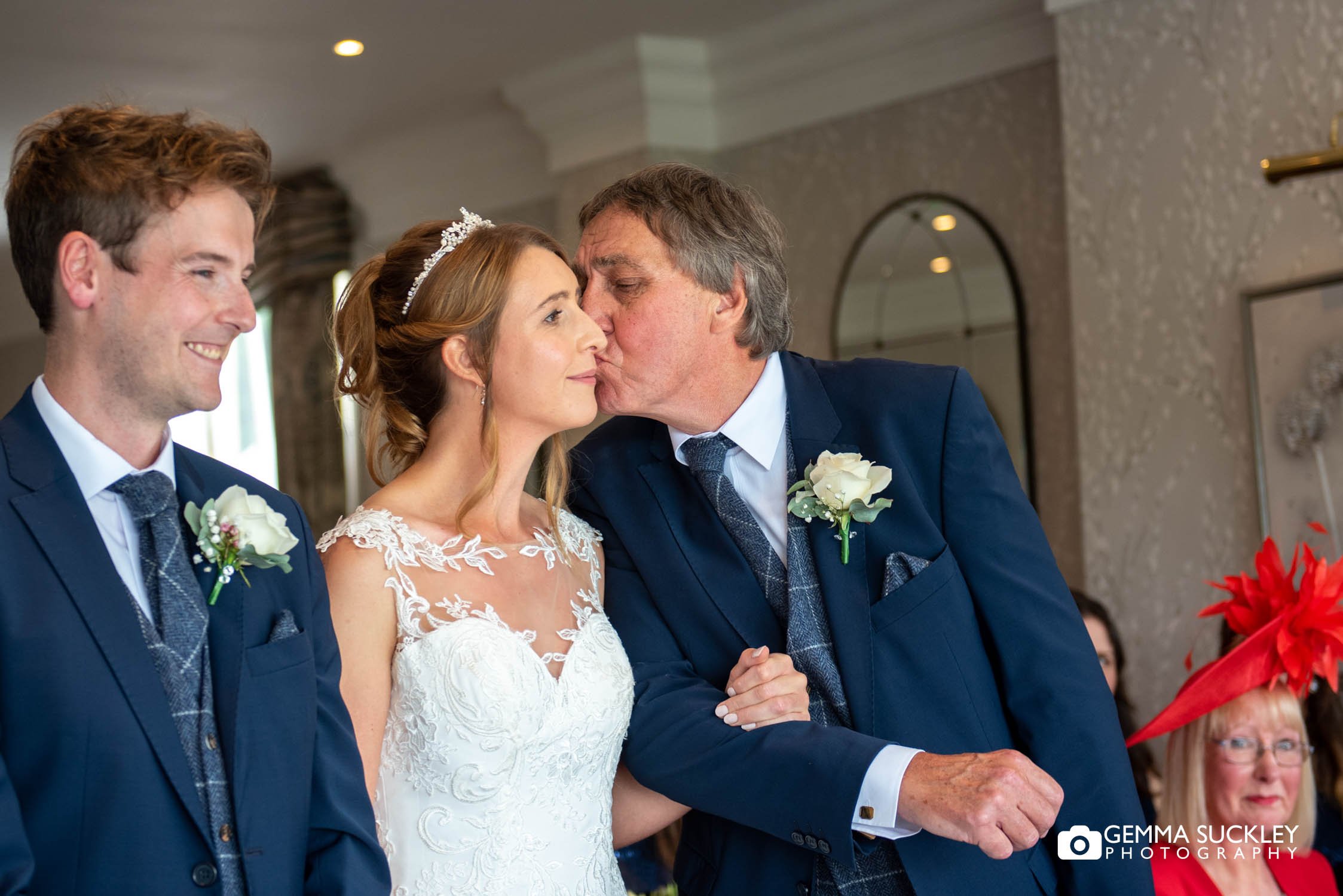 father of the bride kissing his daughter as he gives her away