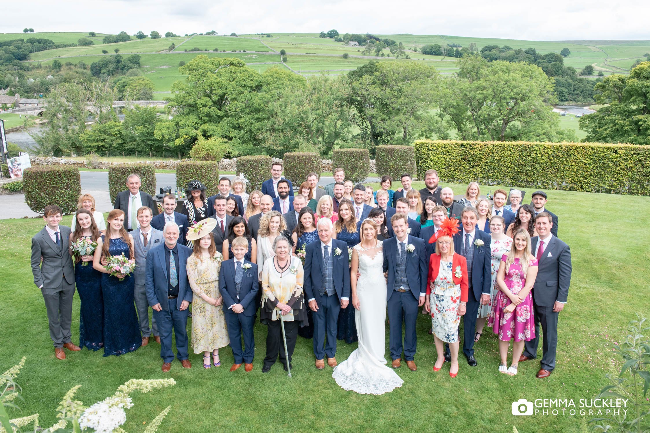 wedding guests outside the devonshire fell with burnsall river behind them