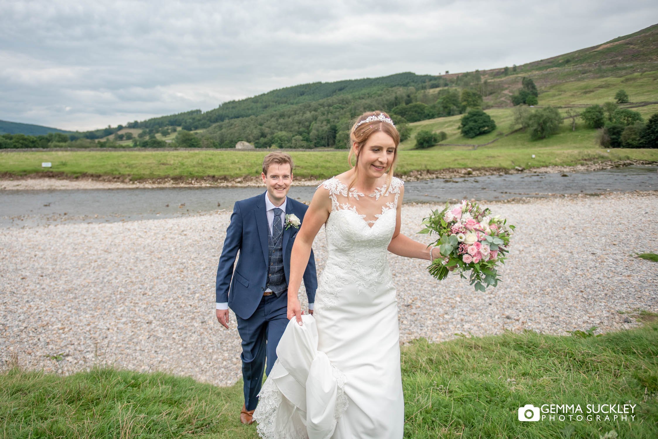 bride and groom walking from the river at burnsall