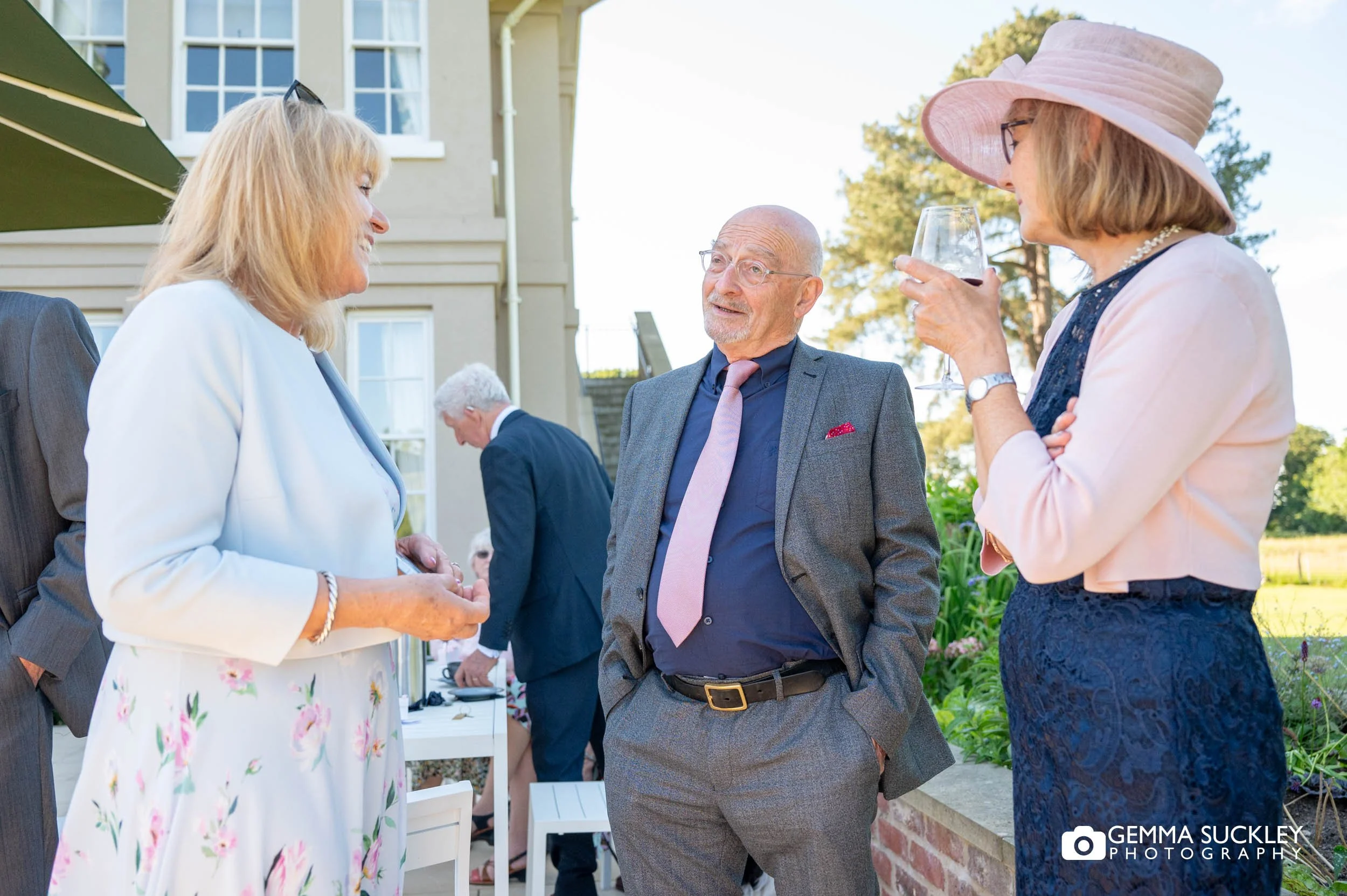 wedding guests laughing in the evening sun