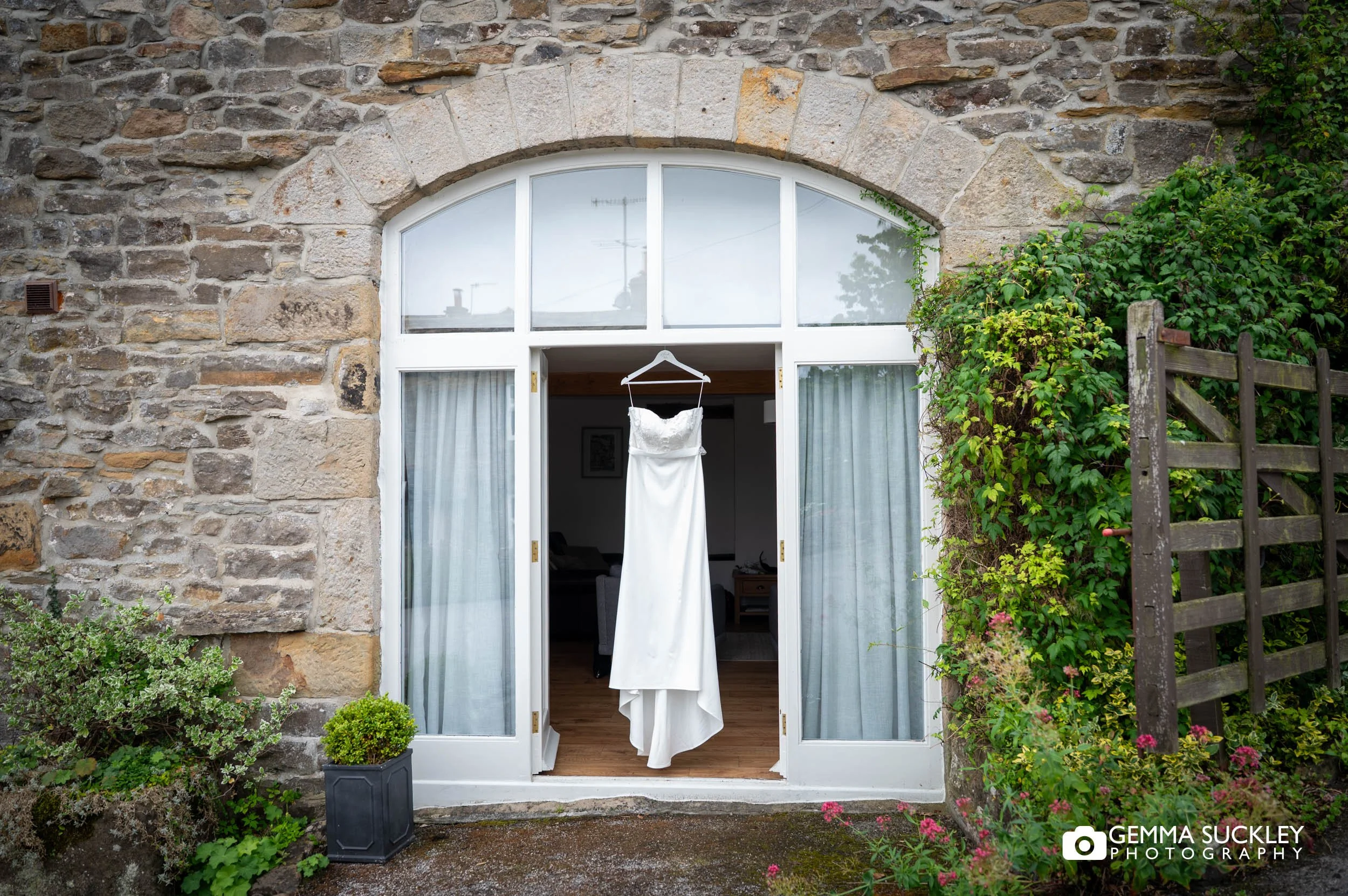 wedding dress hanging in an open doorway