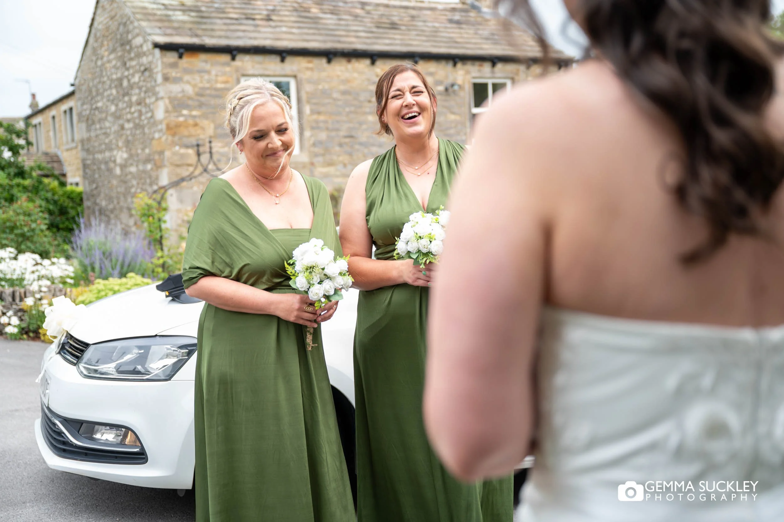 bridesmaids see the bride in her dress