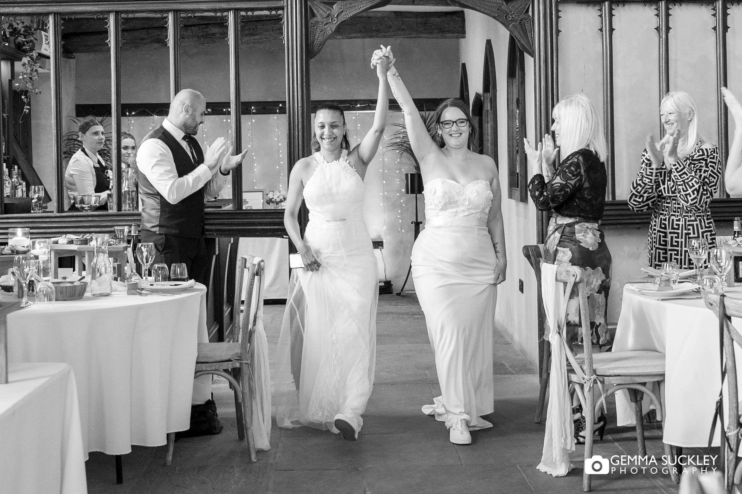 newly-weds enter the priests house with arms in the air