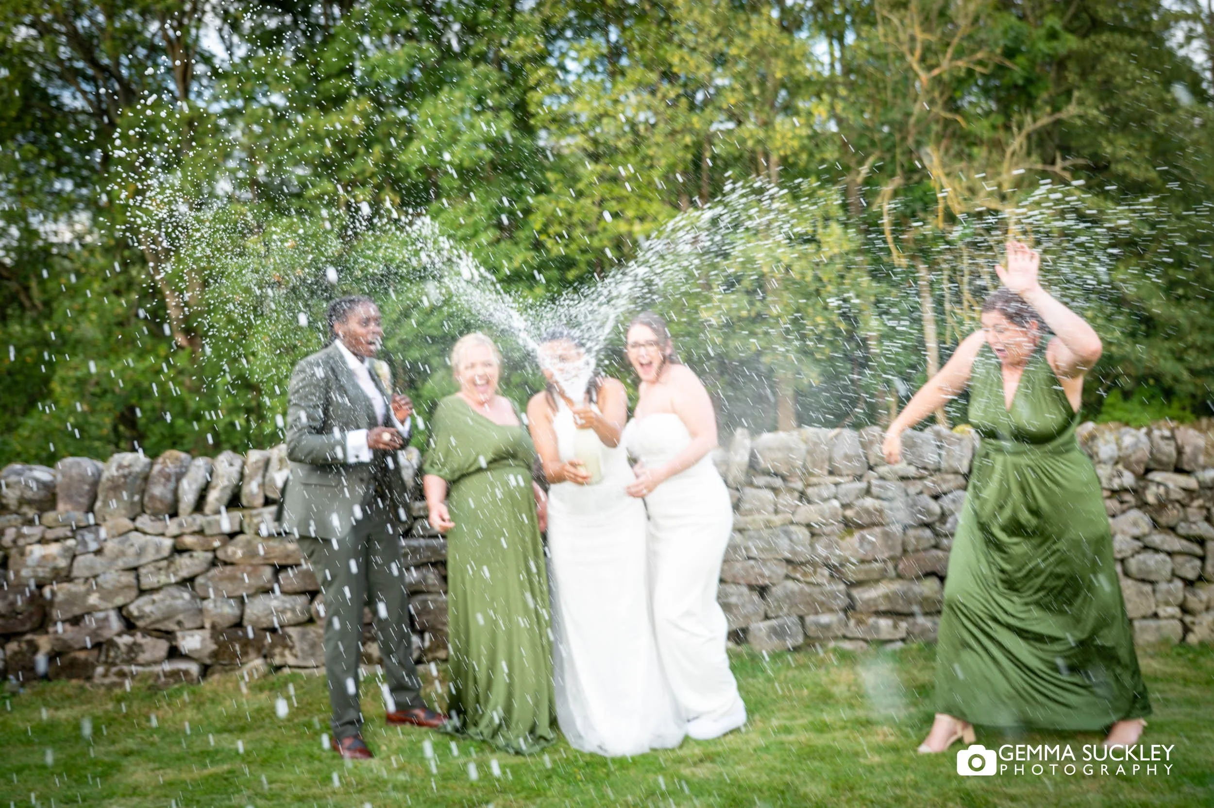 bridal party spray champagne at the priests house