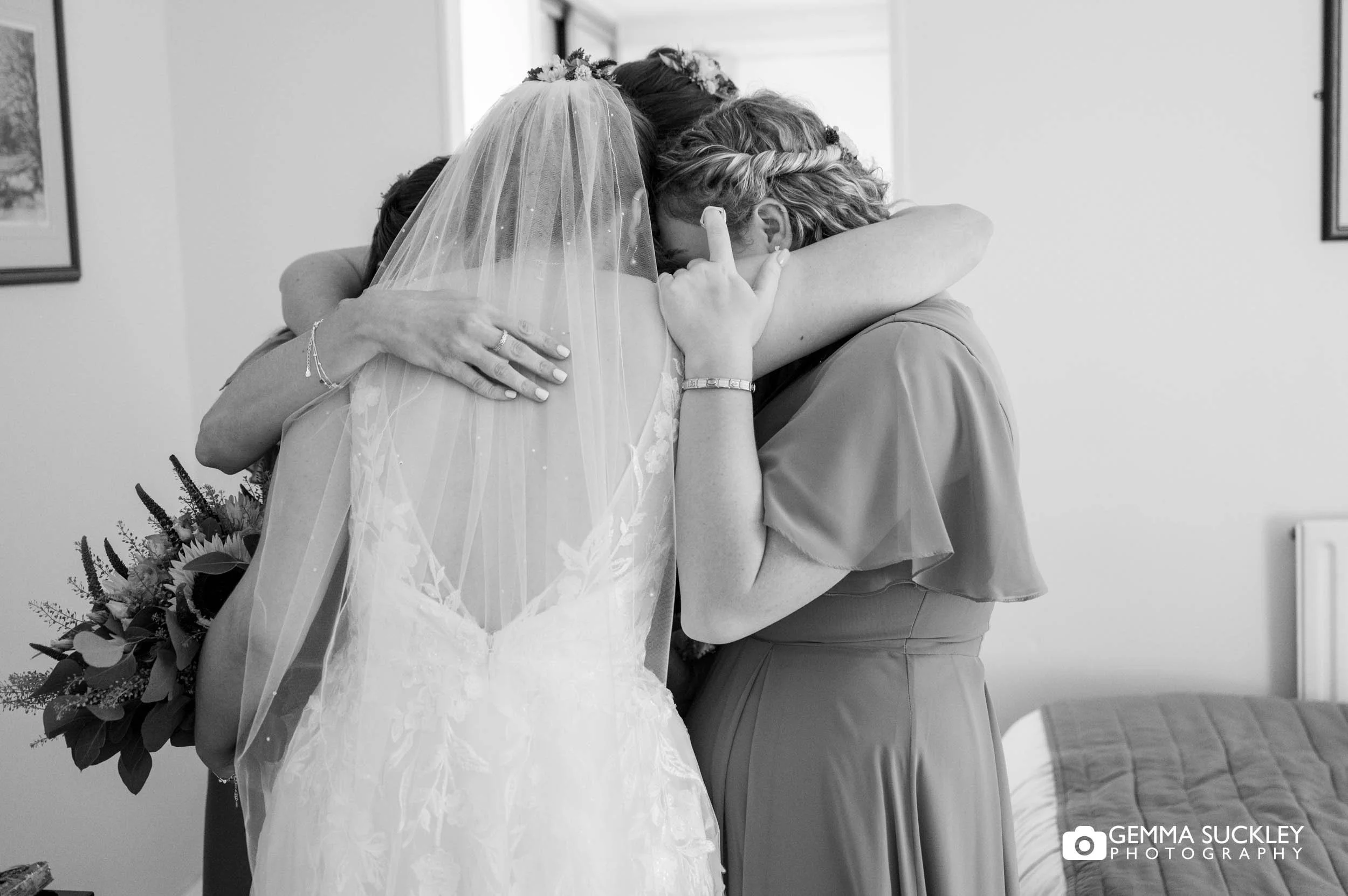 bride and bridesmaids hugging
