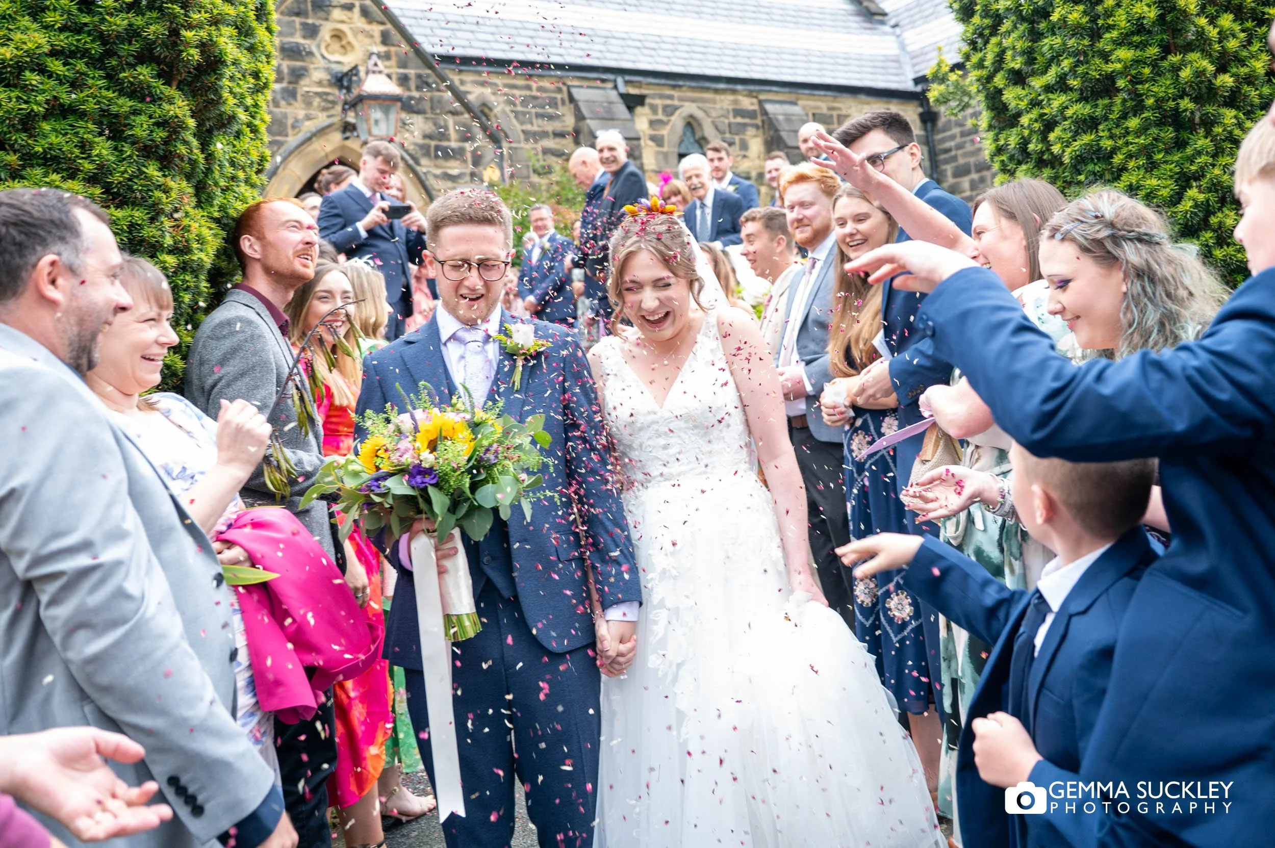 wedding guests throwing confetti at the bride and groom