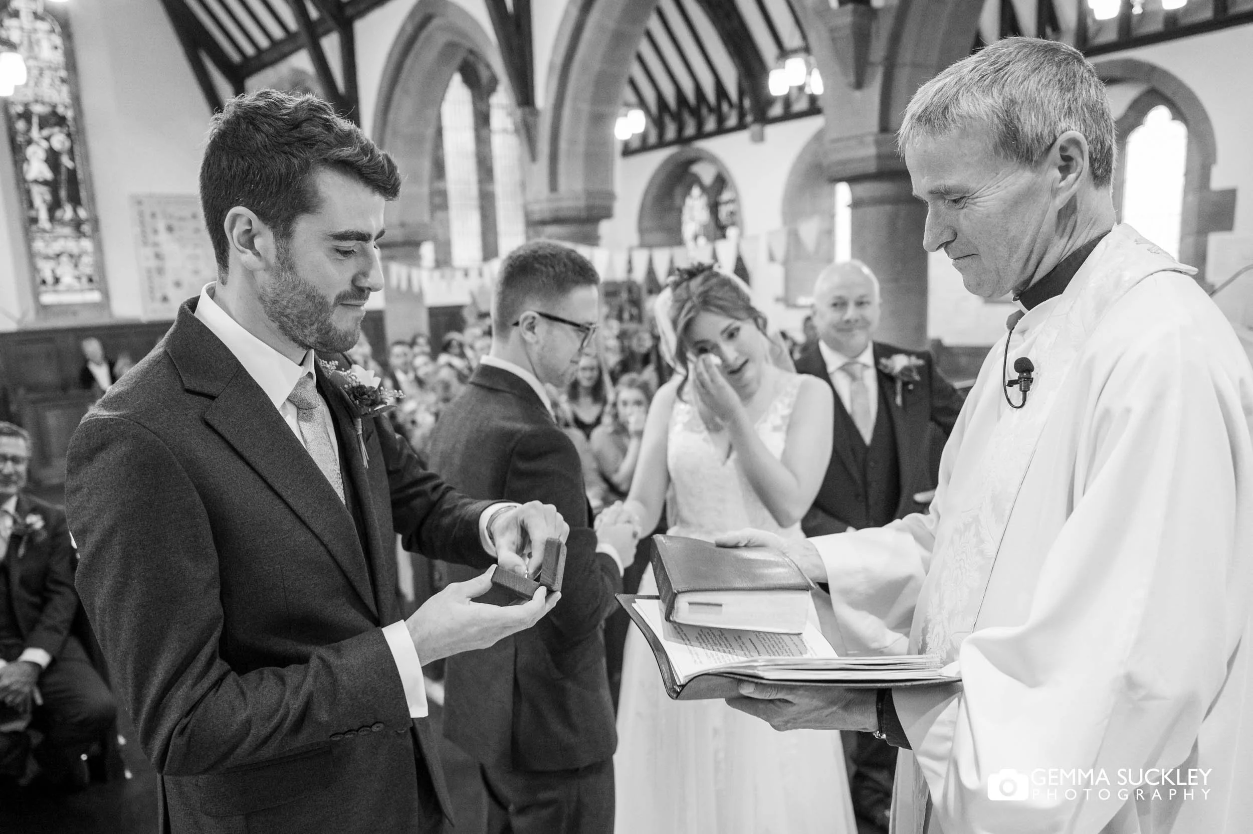 best man handing the rings to the priest