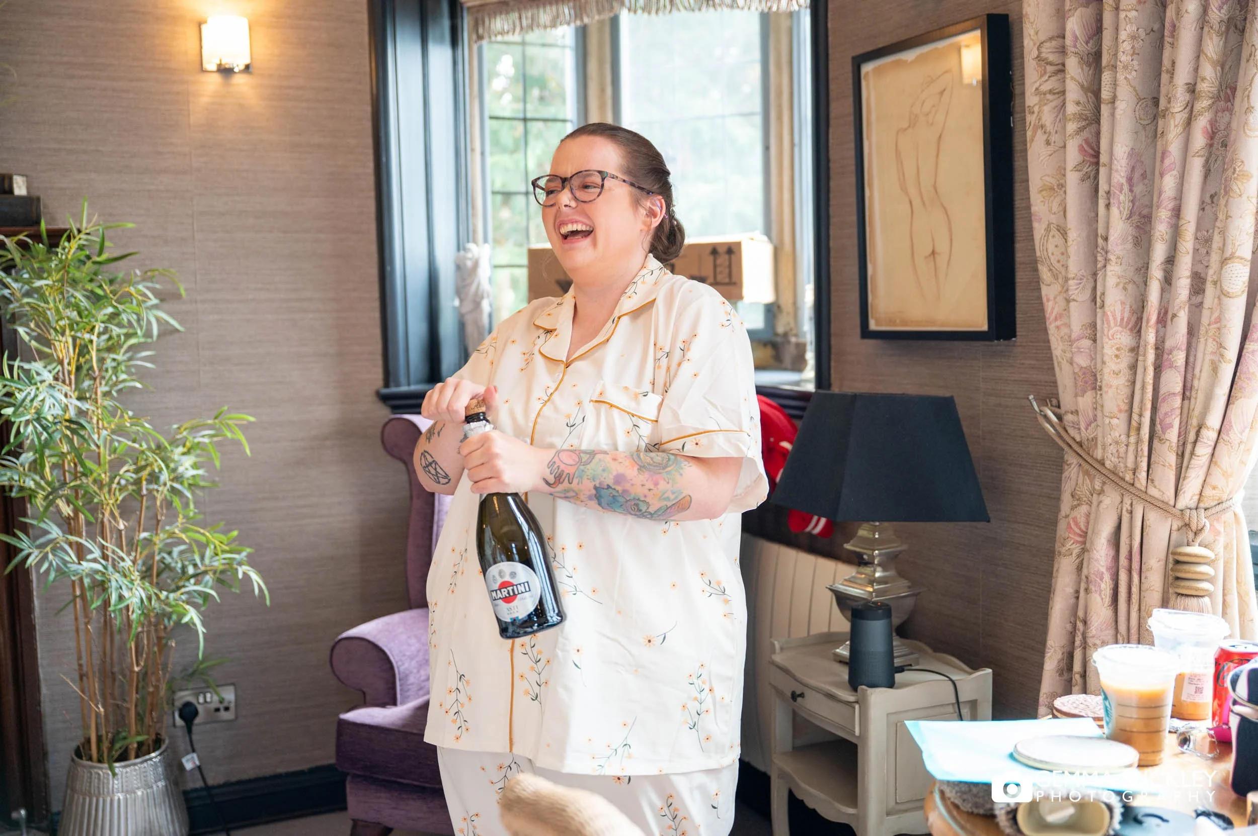 a bridesmaid opening champagne