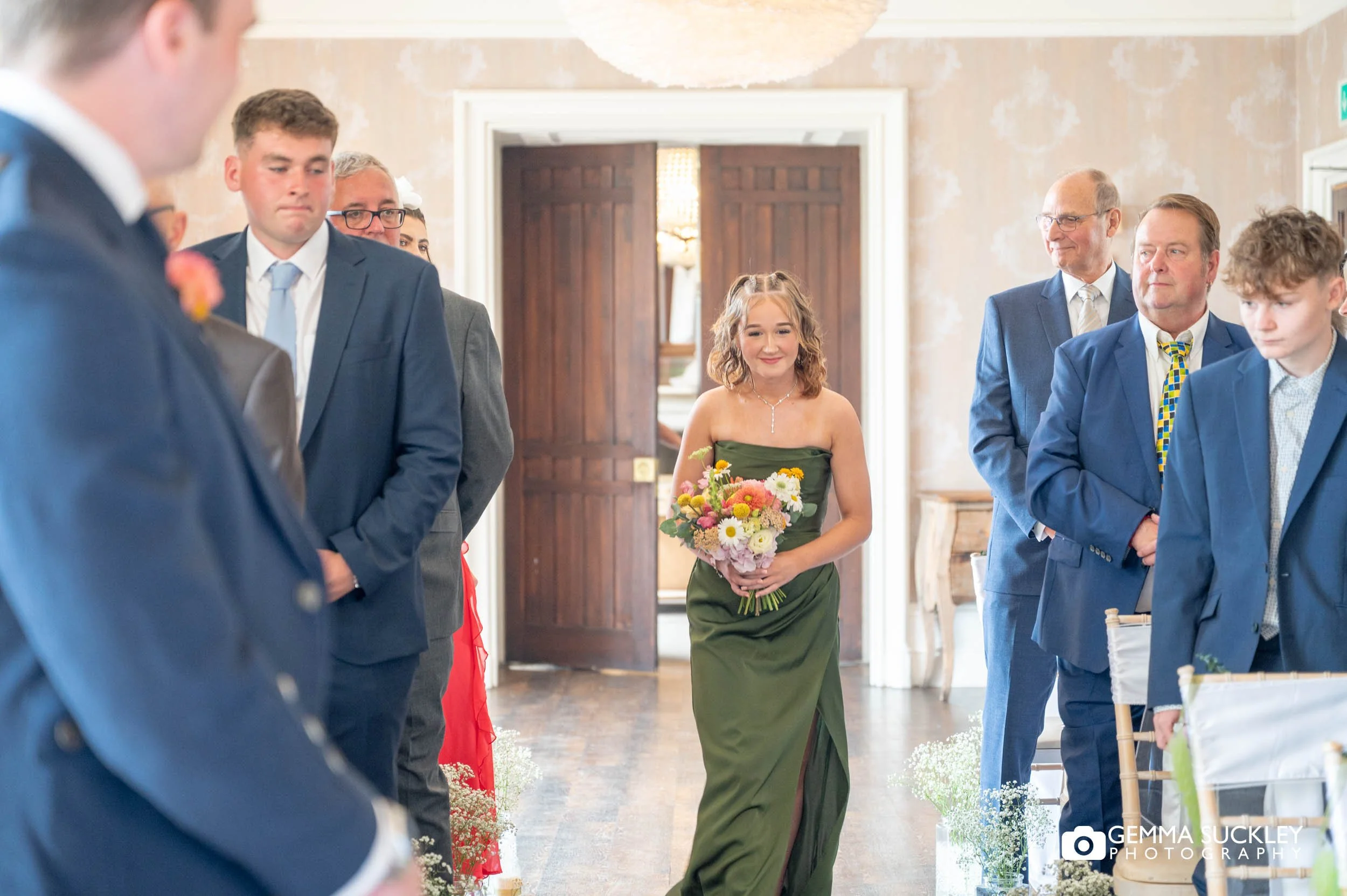 bridesmaid walking down the aisle at the falcon manor