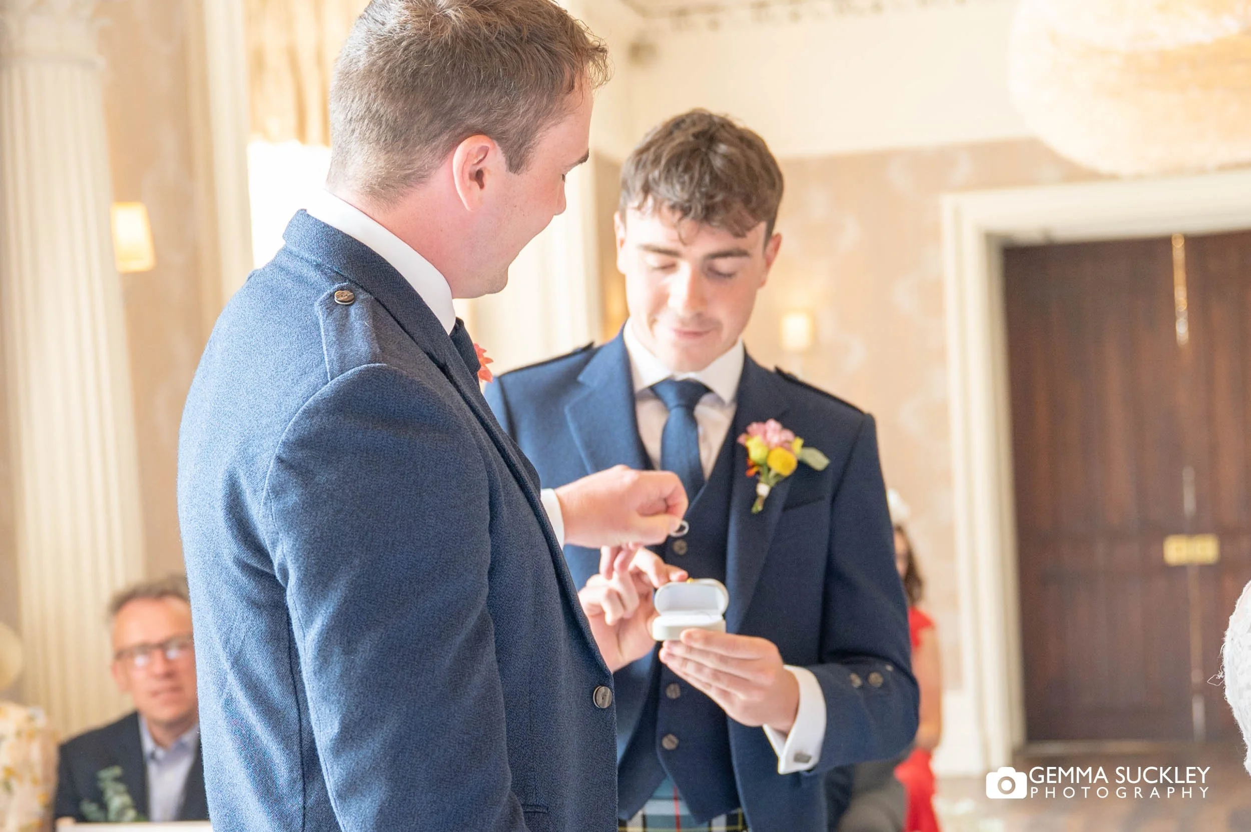 the best man passing the ring to the groom