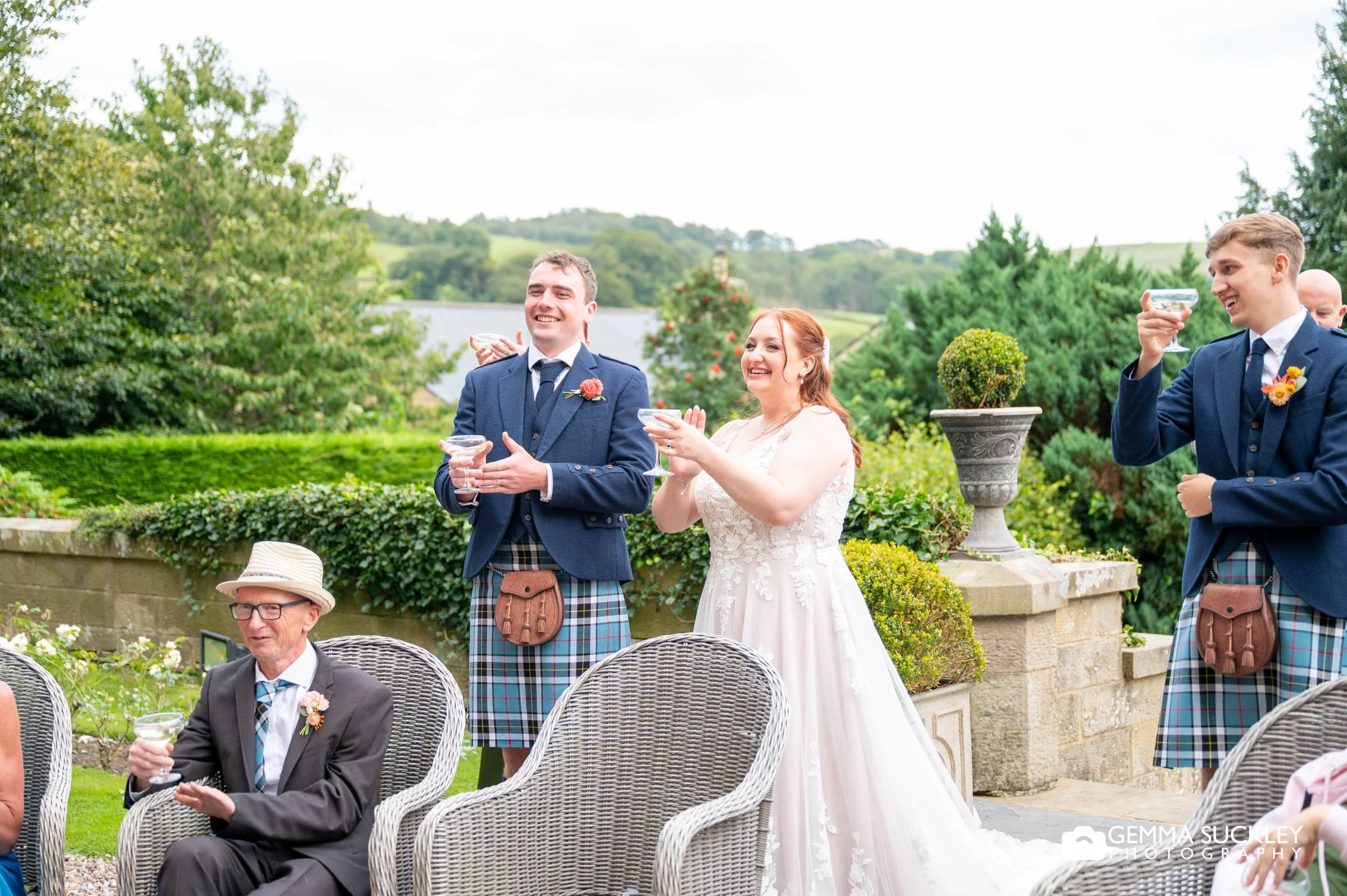 the bride and groom listening to speeches outside the falcon manor