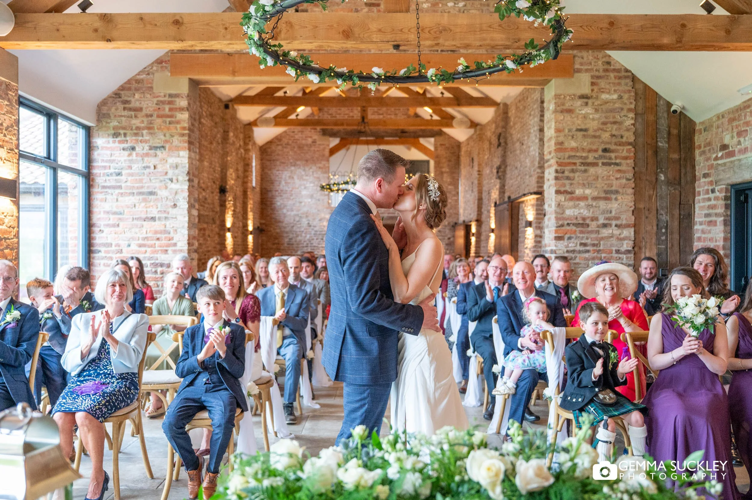 newly-weds kissing at thirsk lodge barn wedding ceremony