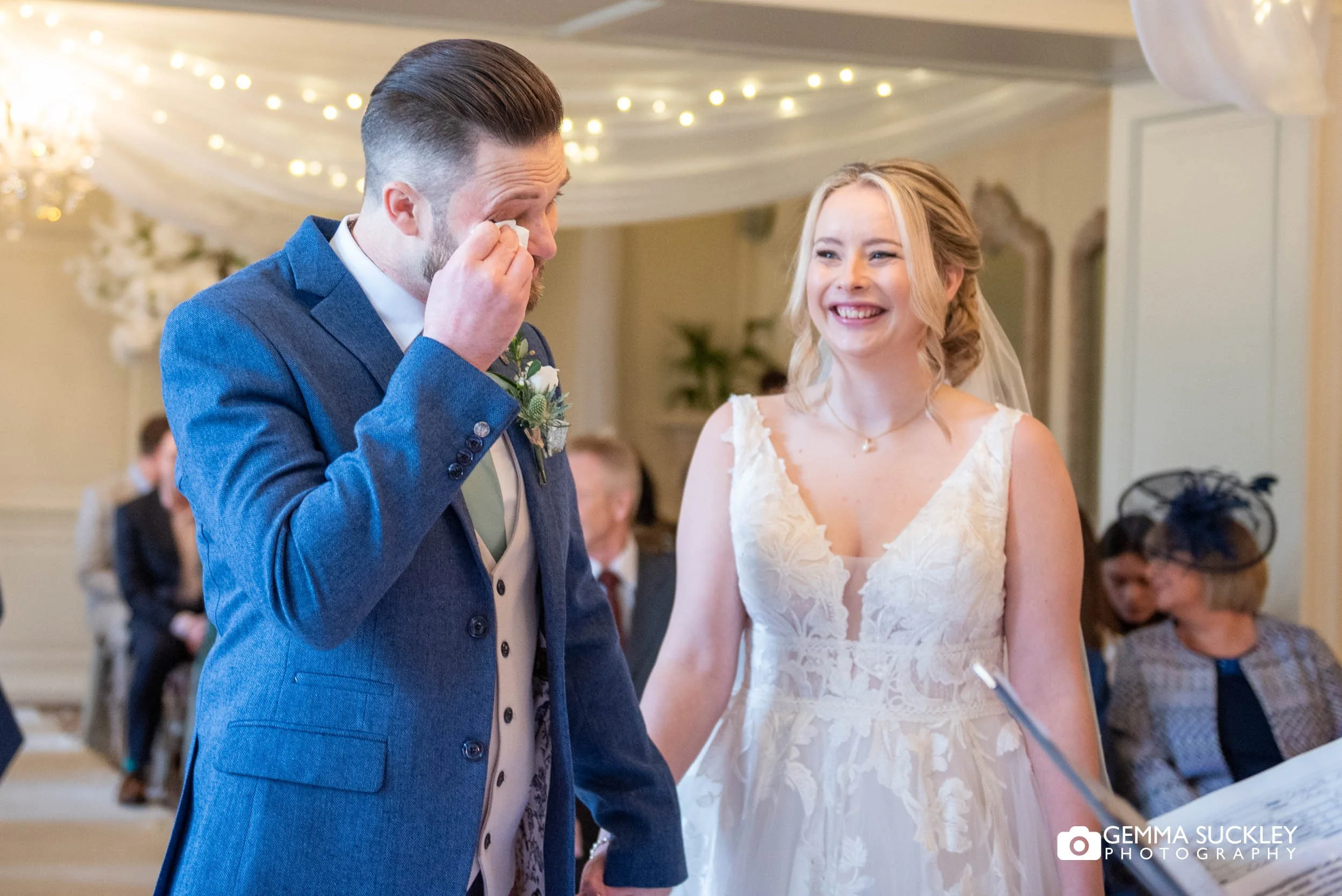 groom wiping his eyes at wedding ceremony