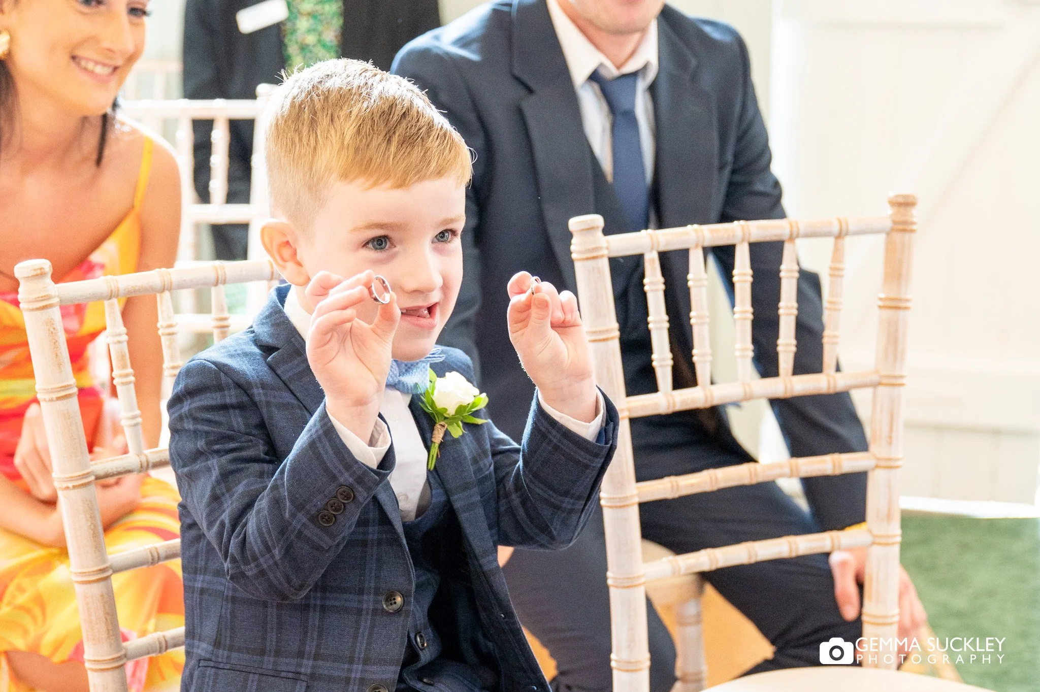 page boy holding up the rings