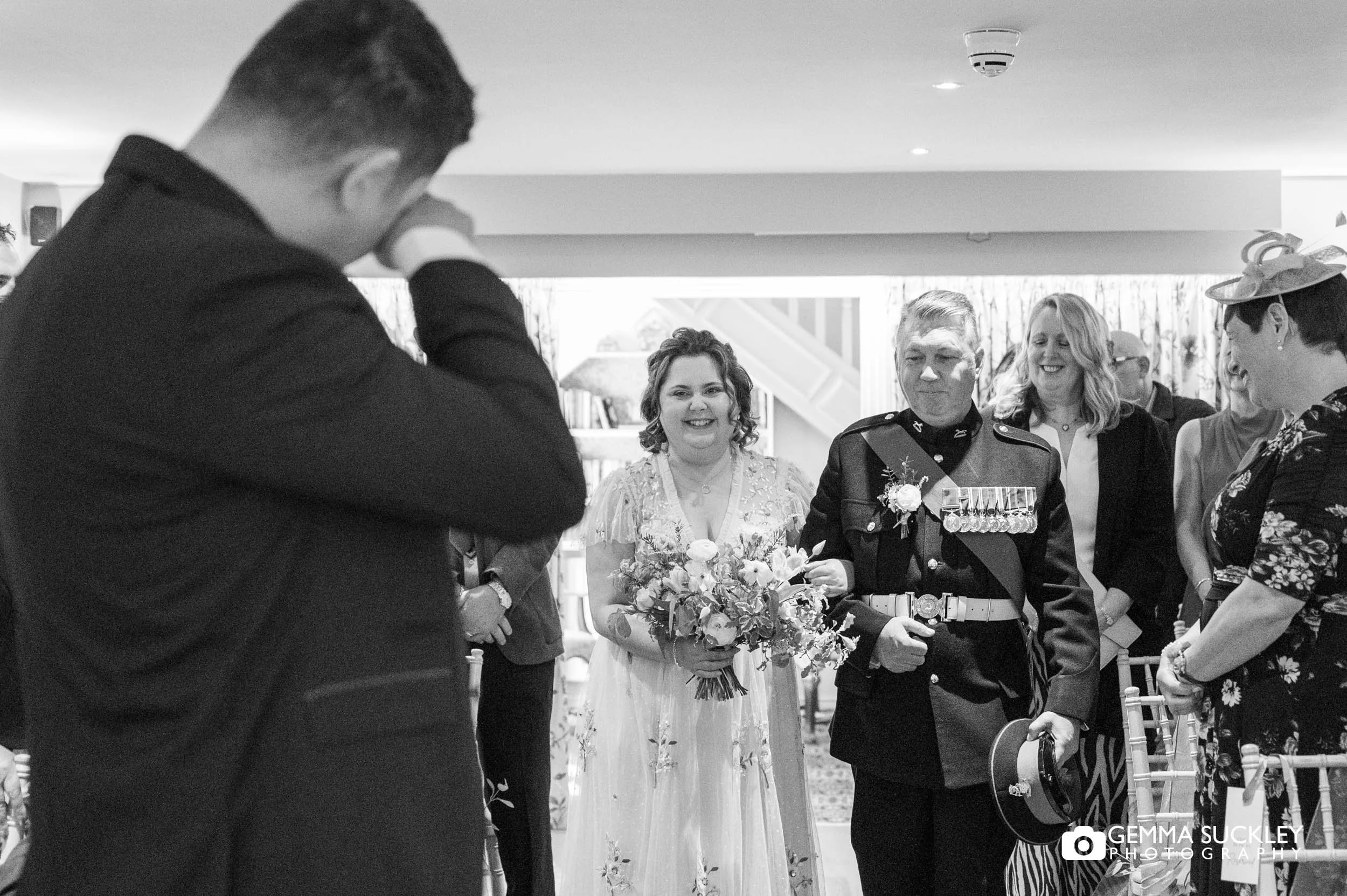 groom crying at his bride walks down the aisle 
