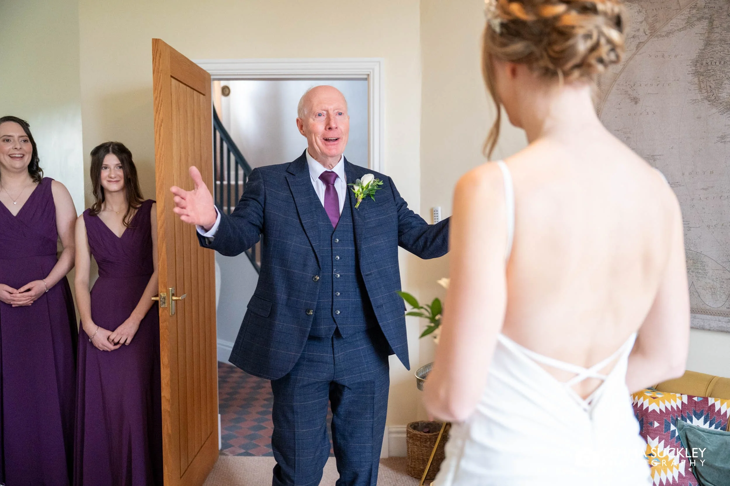brides father holding out his arms to the bride