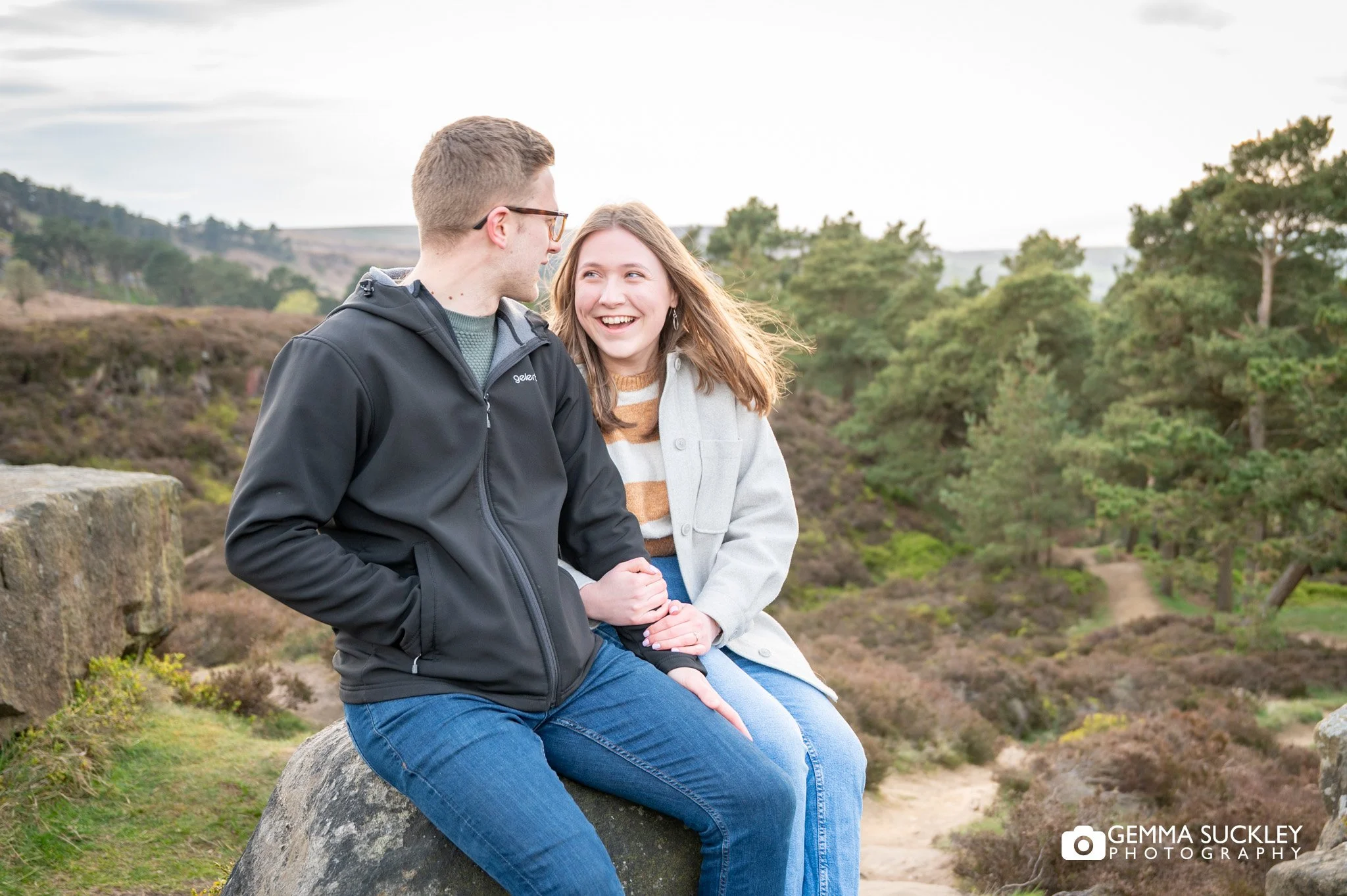 a couple sitting on the rocks on ilkley moor