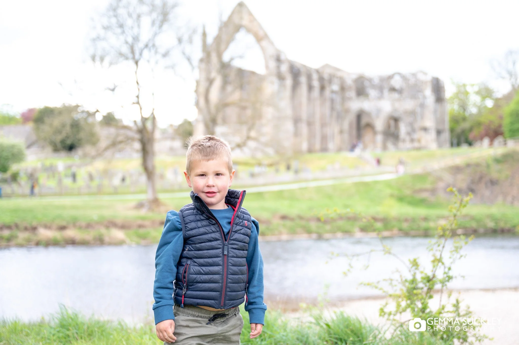 a little boy in front of abbey priory at bolton abbey