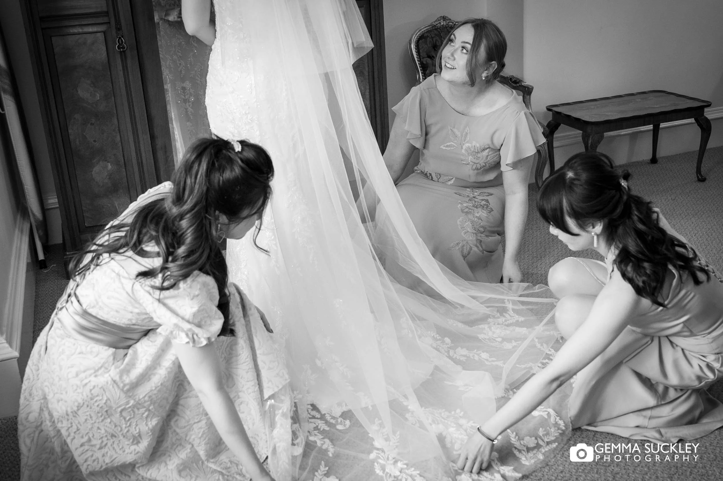 bridesmaids fanning out the brides dress