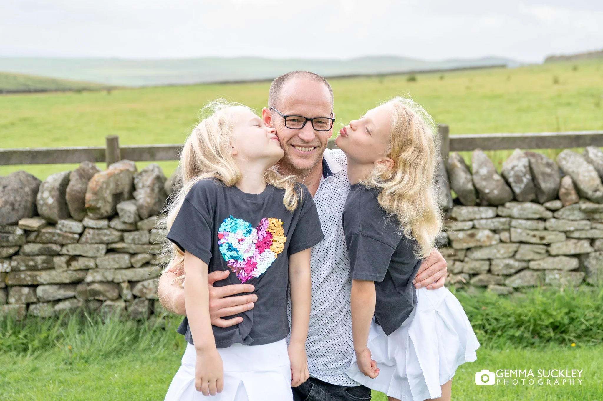 twins kissing their dad