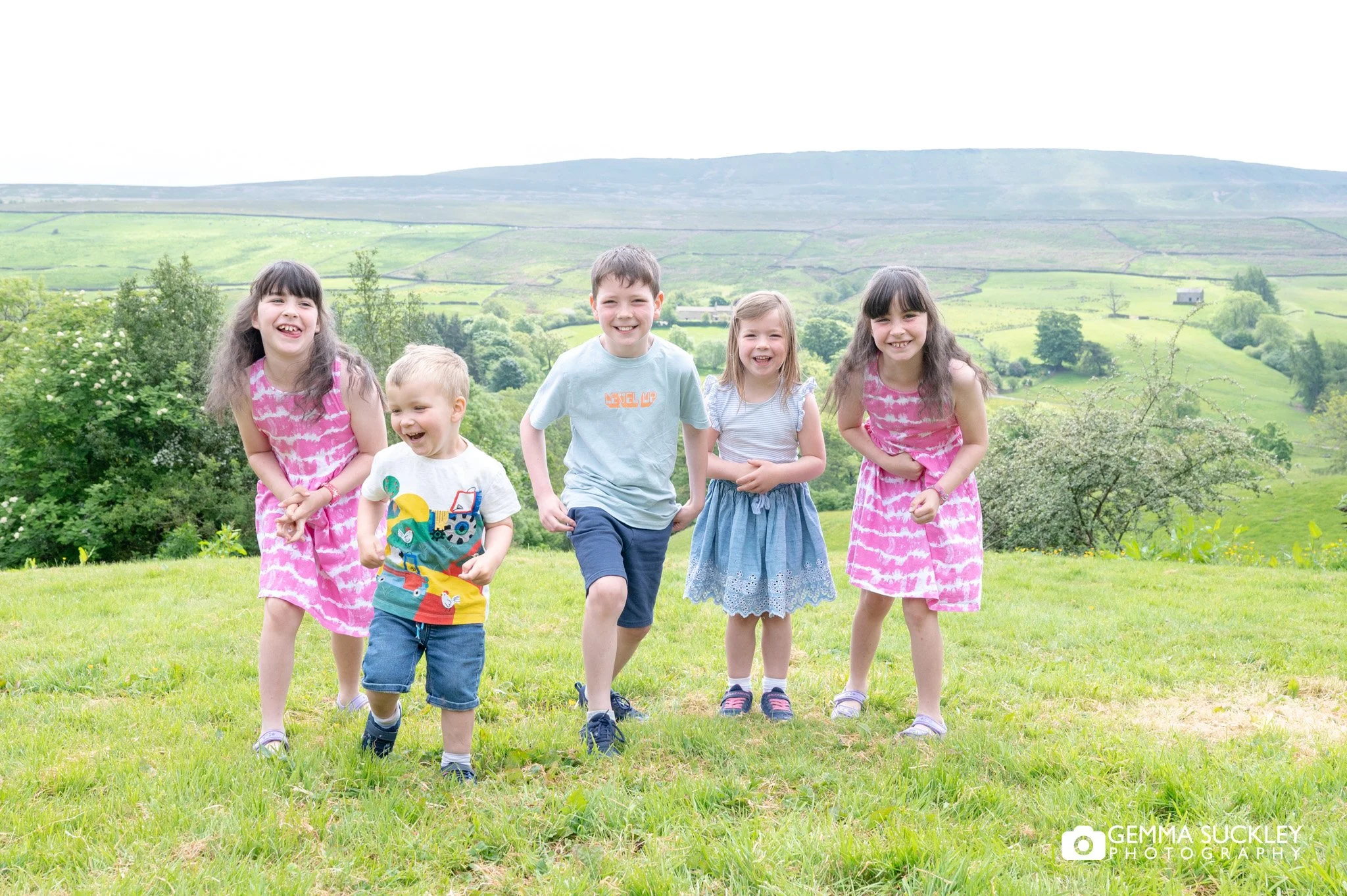 a group of children run in the yorkshire dales