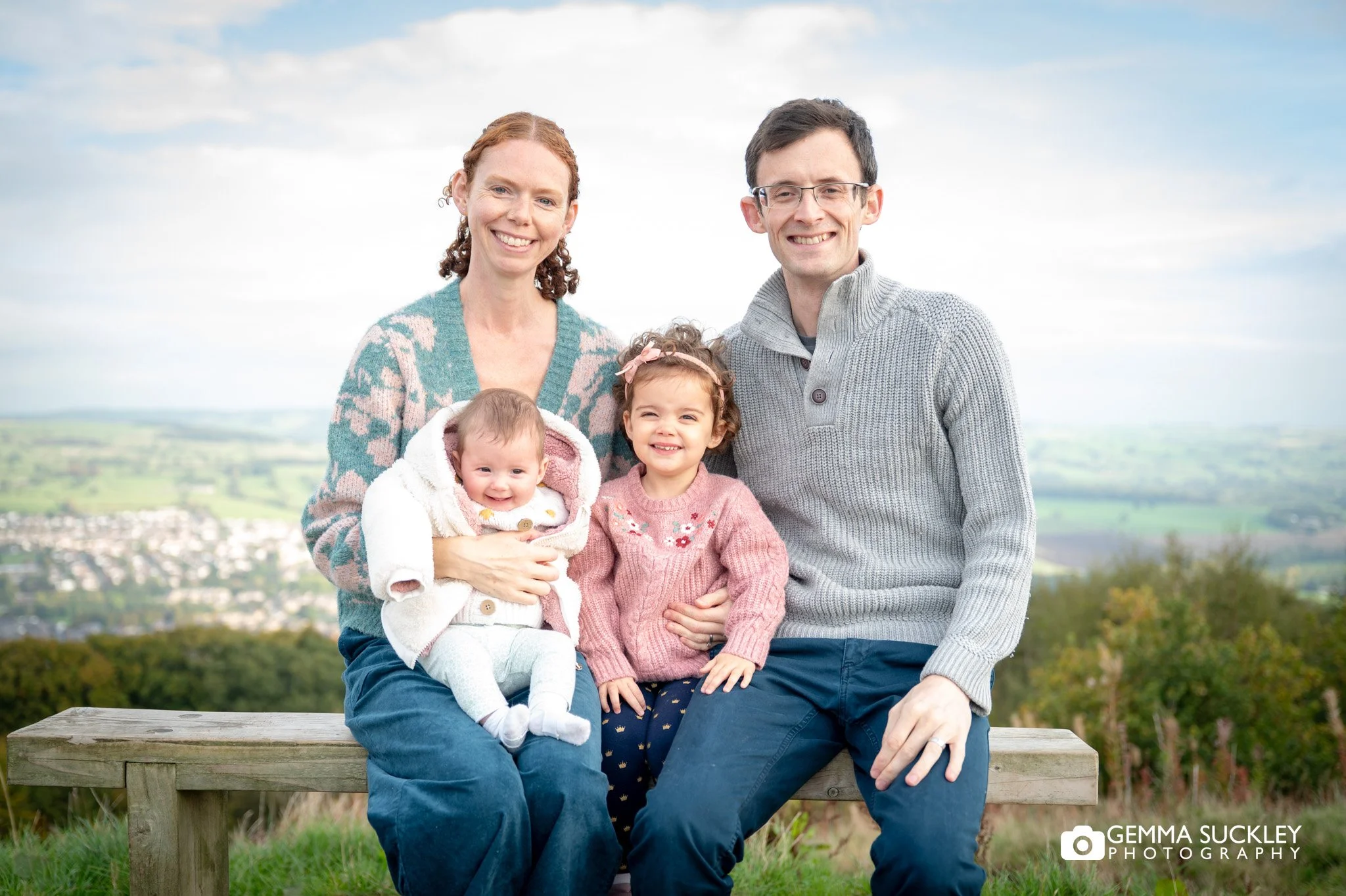 parent with their baby and little girl sitting on their knee