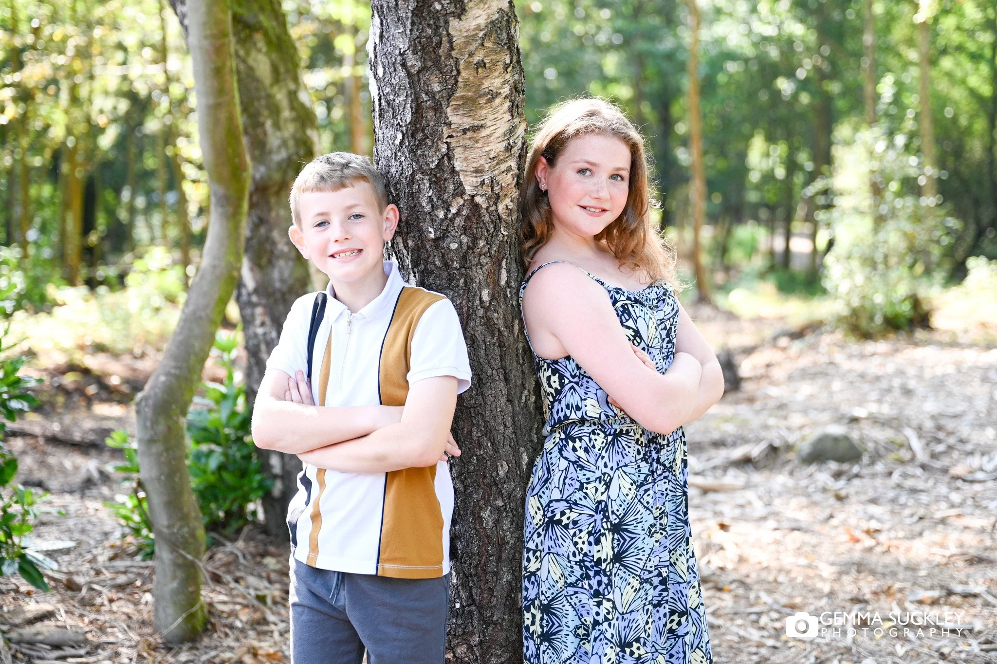 brother and sister posing leaning on a tree