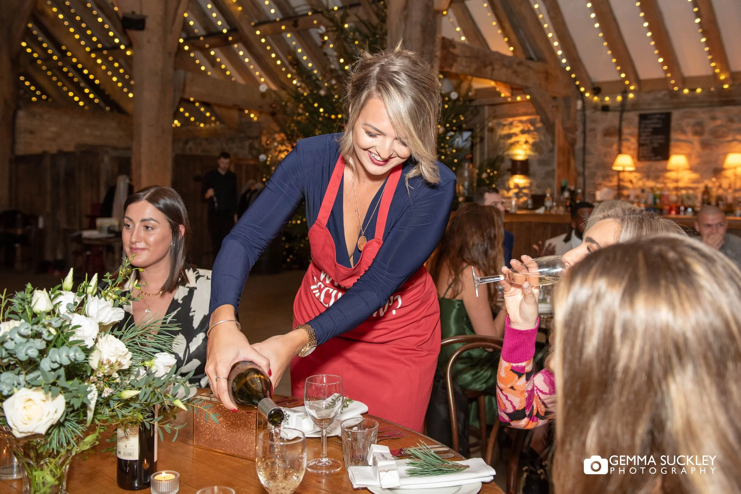 wedding guest serving wine at the tithe barn