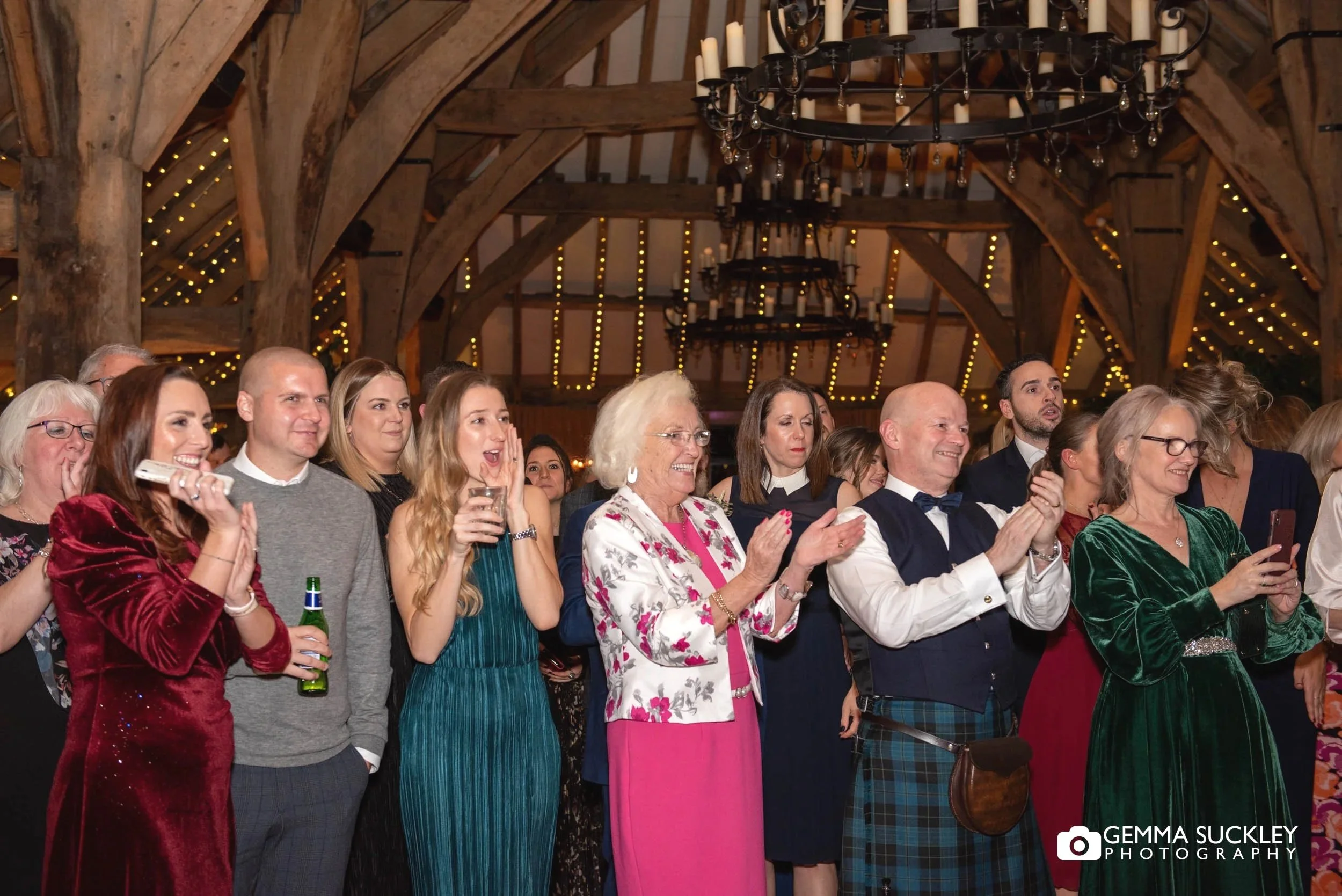 wedding guest cheers the couple at the tithe barn 