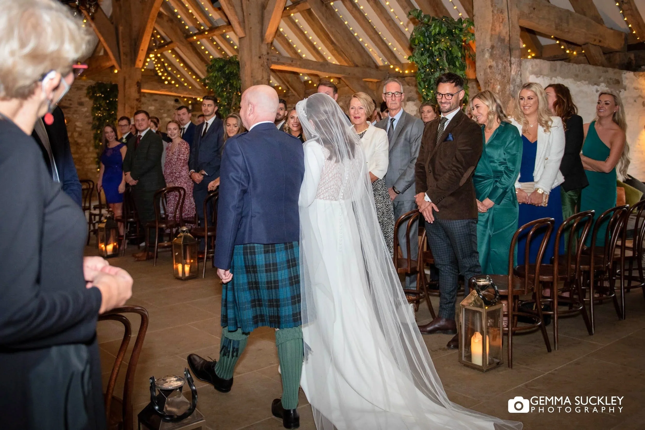bride walking down the aisle as wedding guest watch