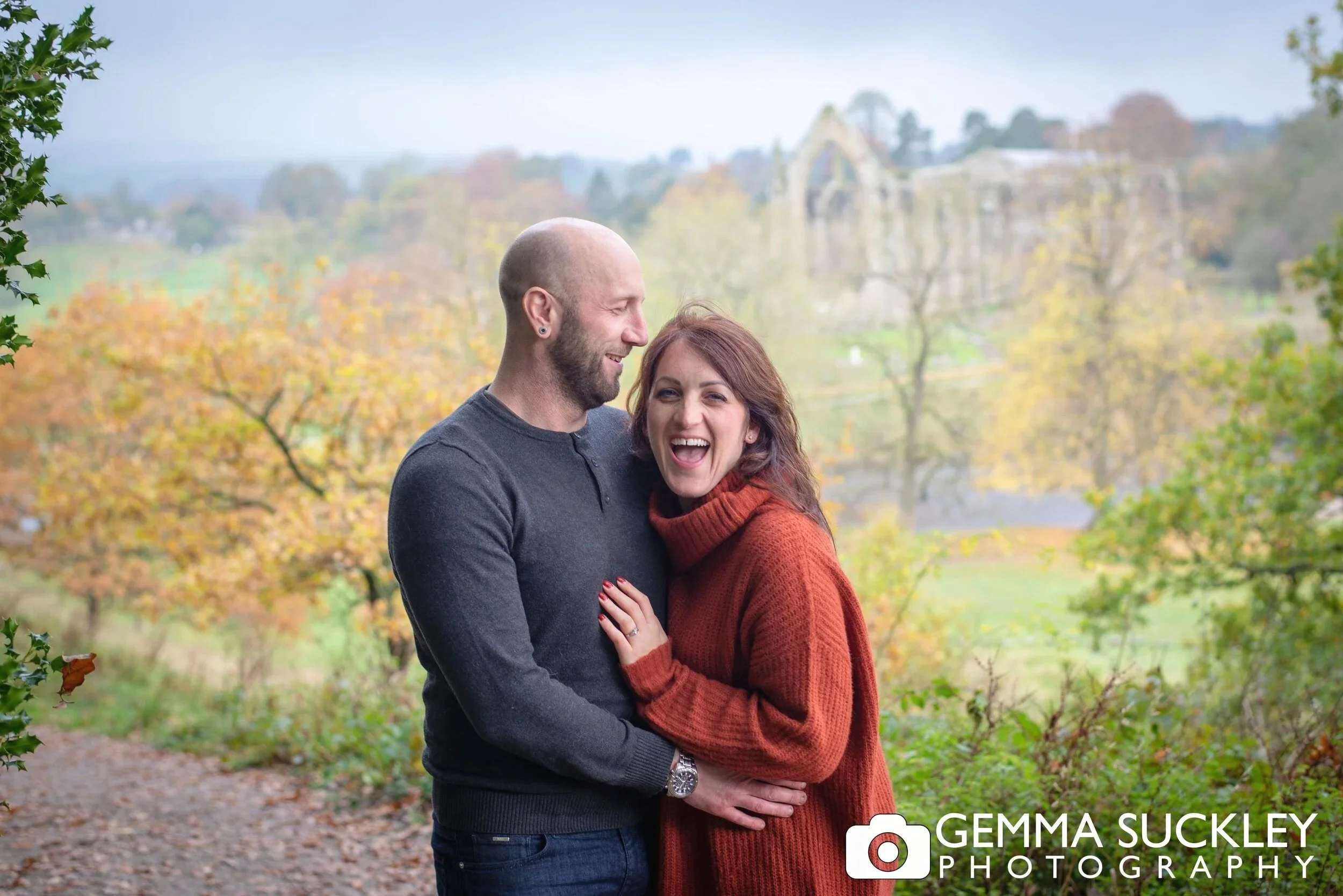 an engaged couple having their photo taken at bolton abbey