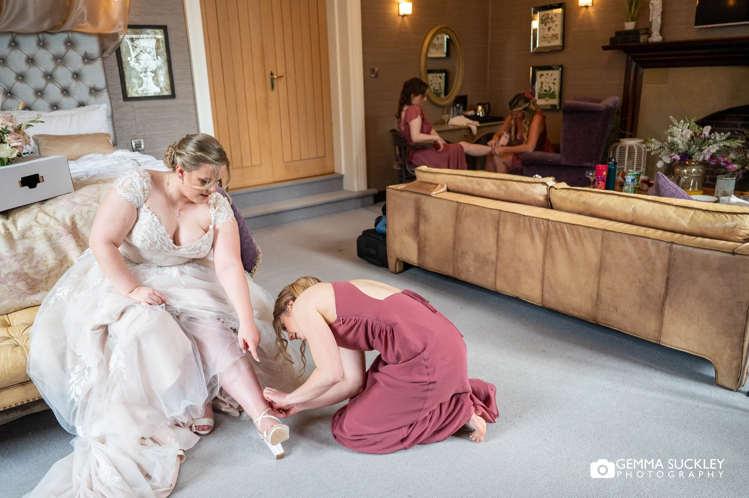 bride and bridesmaid putting on shoes at the falcon manor