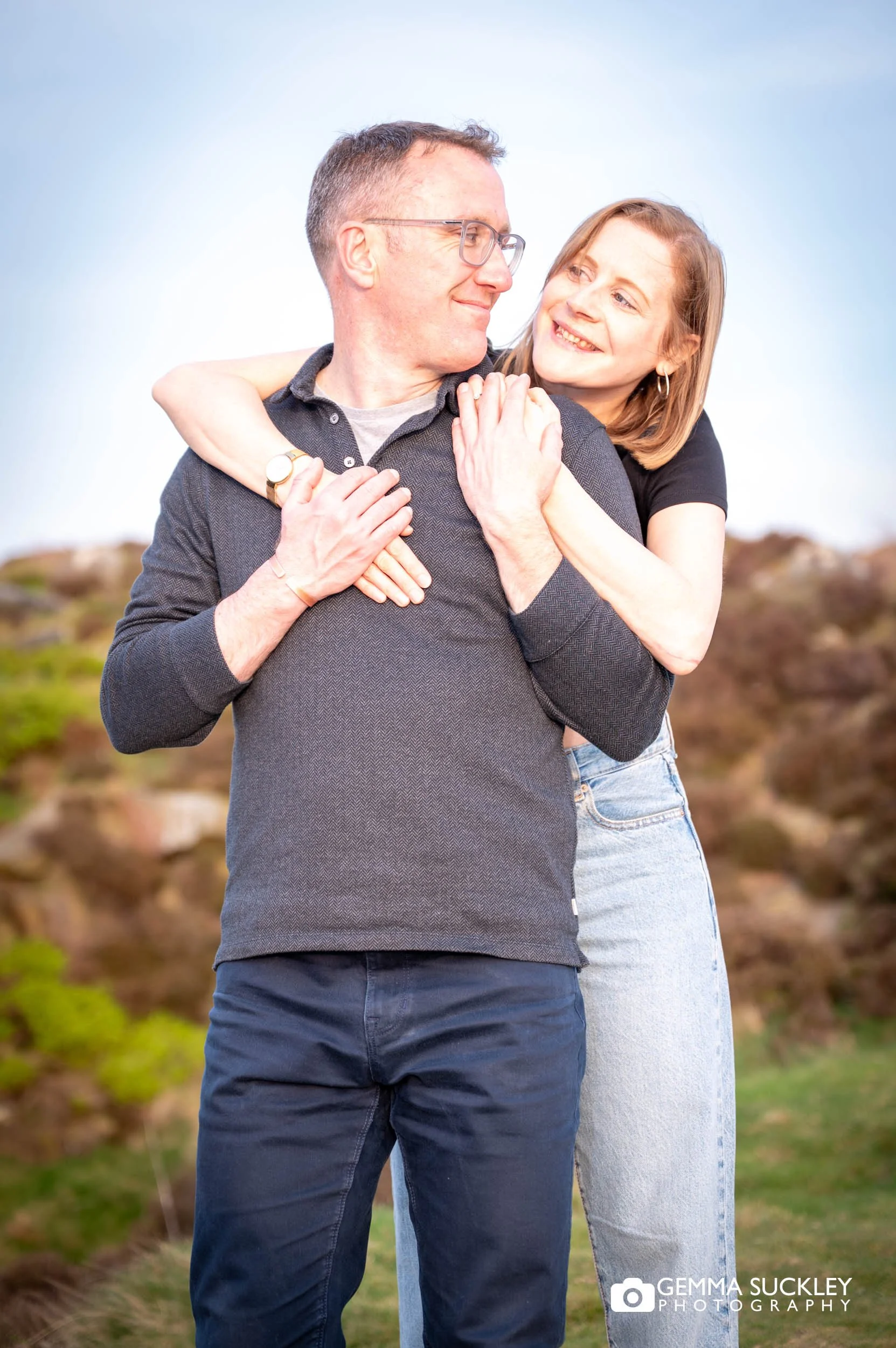 Couple hugging on Ilkley Moor during sunset engagement shoot