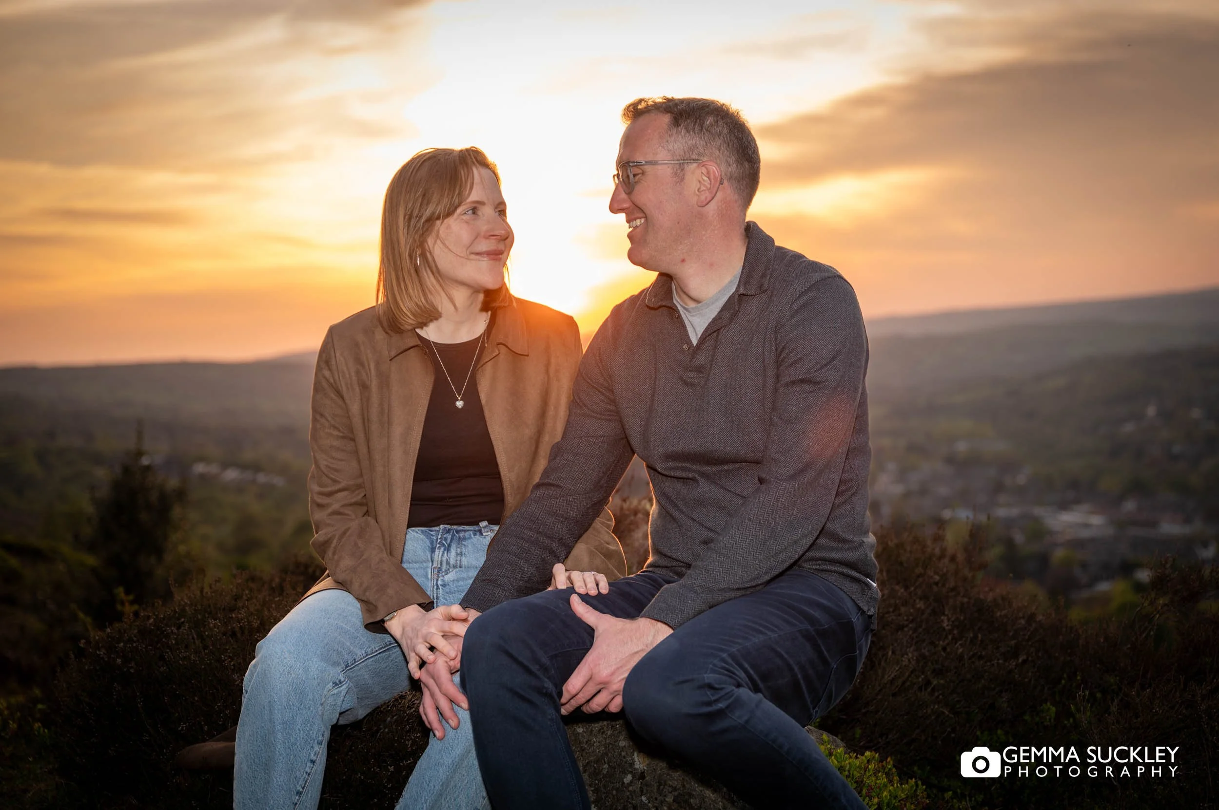 couple sitting on ilkley moor at sunset during their engagement shoot
