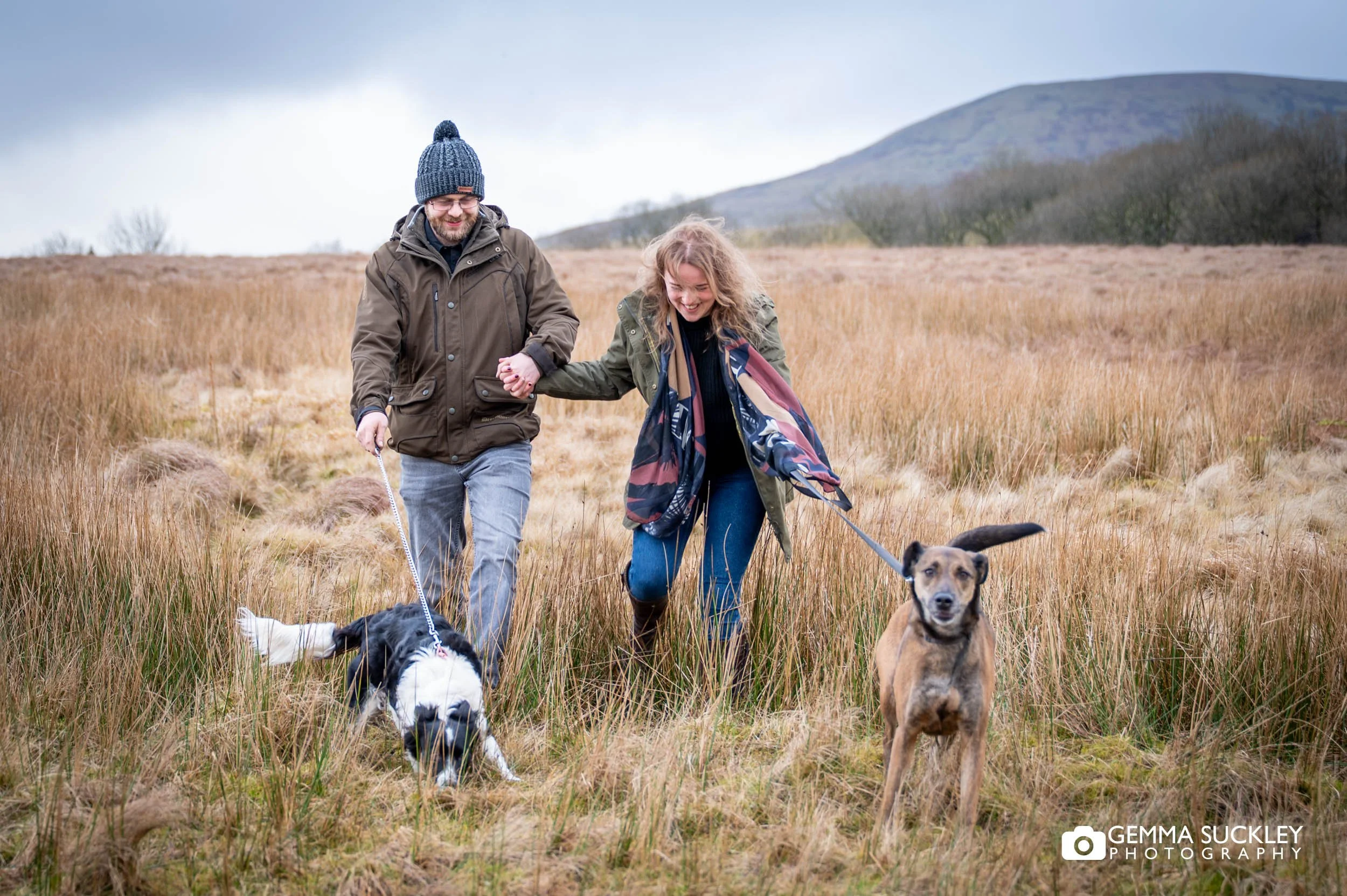 couple walking their dogs near ribblehead viaduct yorkshire dales