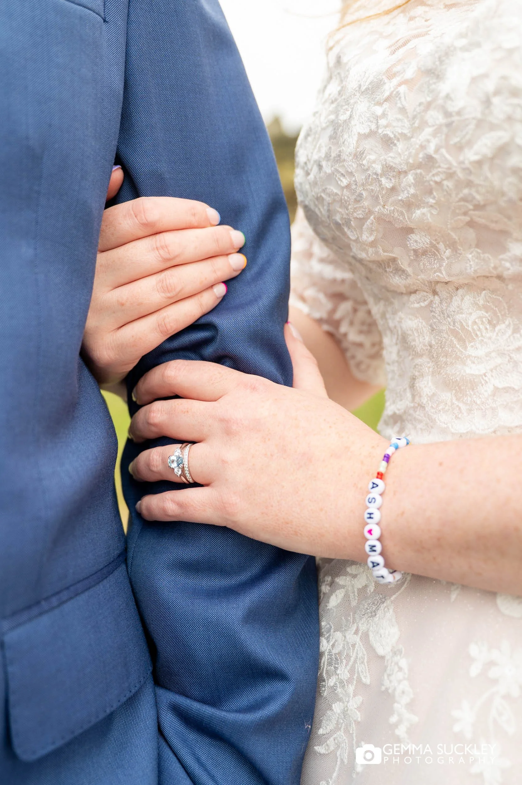 close up for brides hands holding her new husbands arm