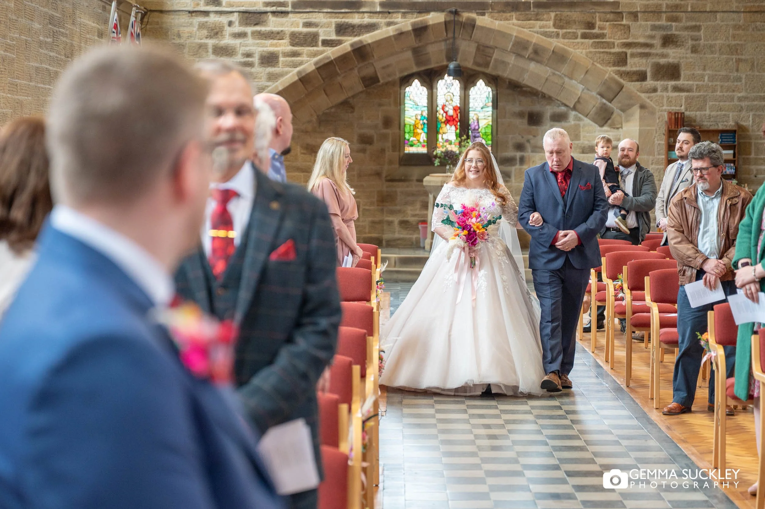 Groom reacting as he sees the bride walk down the aisle