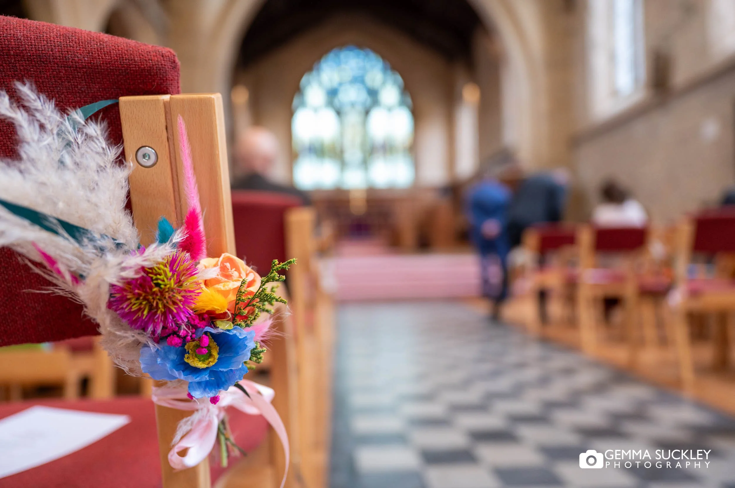 flowers on the seats at ilkley church wedding