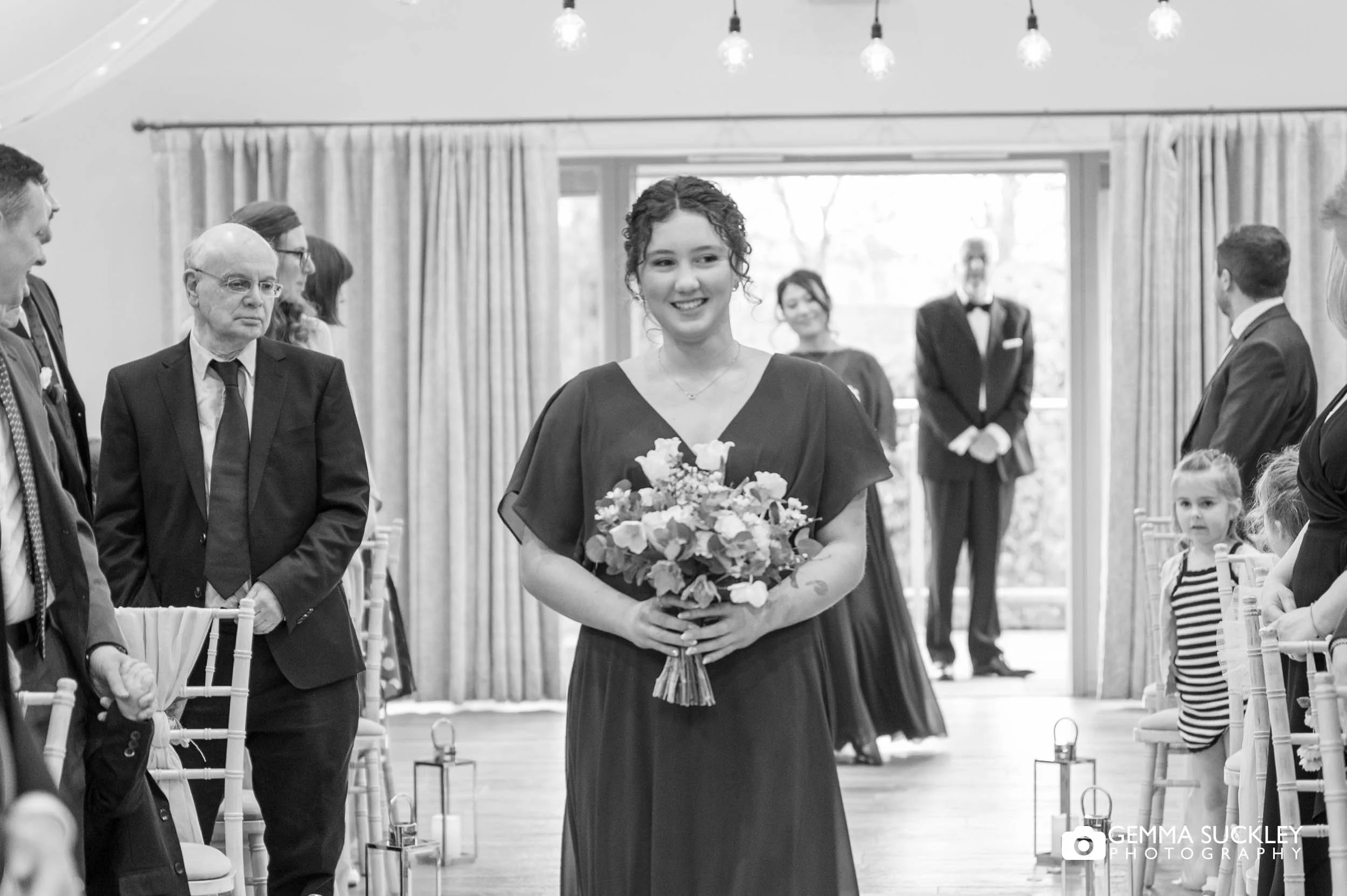 Bridesmaid walking down the aisle at The Gamekeeper’s Inn wedding ceremony