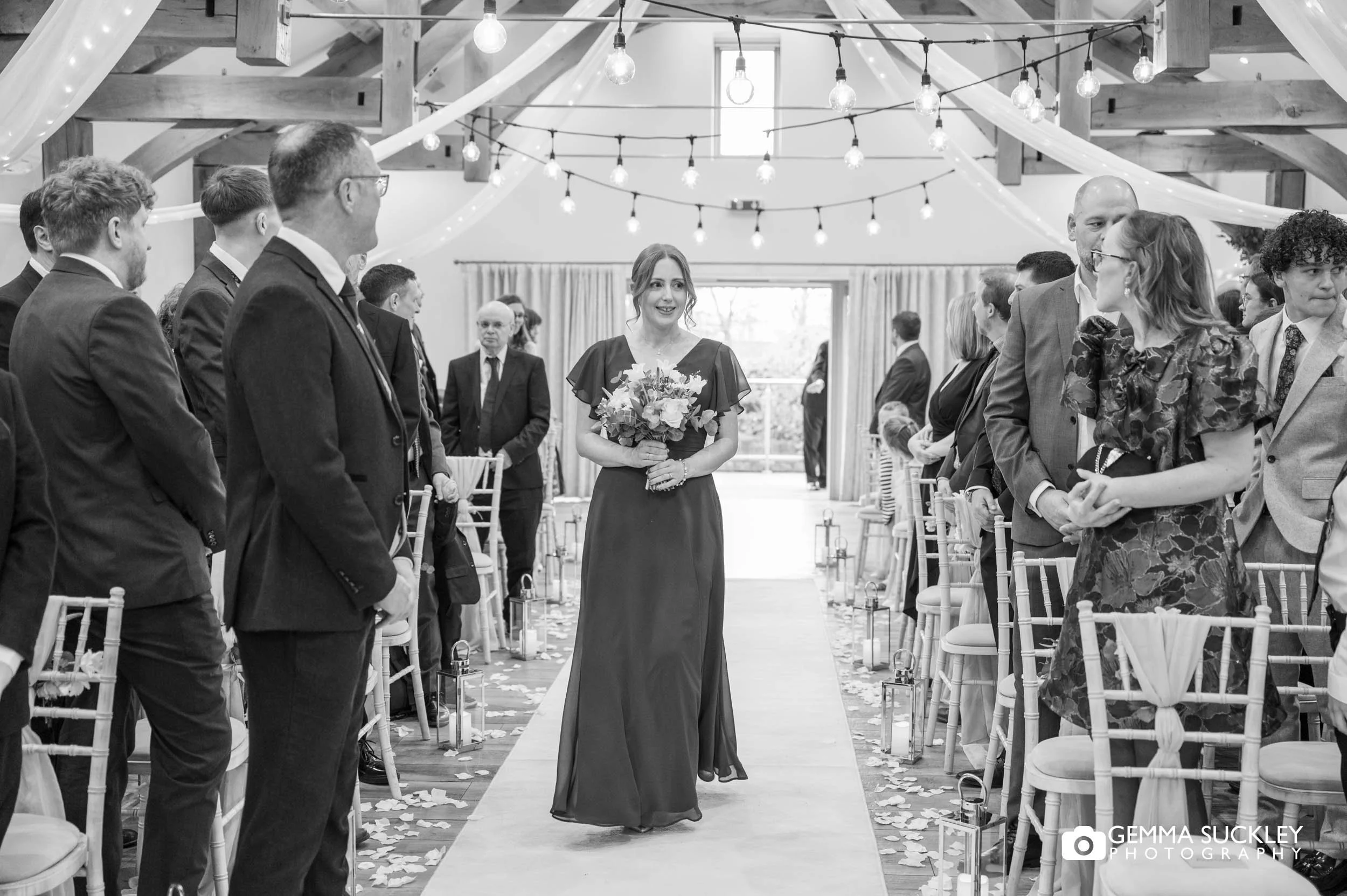 Bridesmaid walking down the aisle at The Gamekeeper’s Inn wedding ceremony