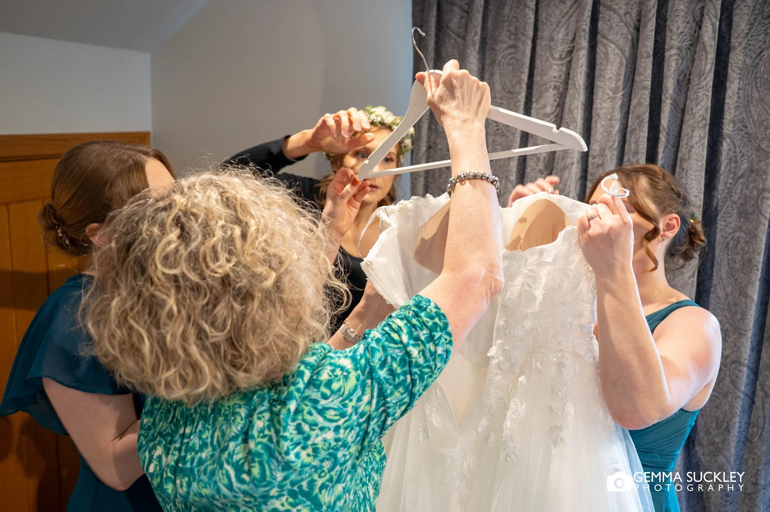 bridal party helping the bride wit her dress at the gamekeepers inn