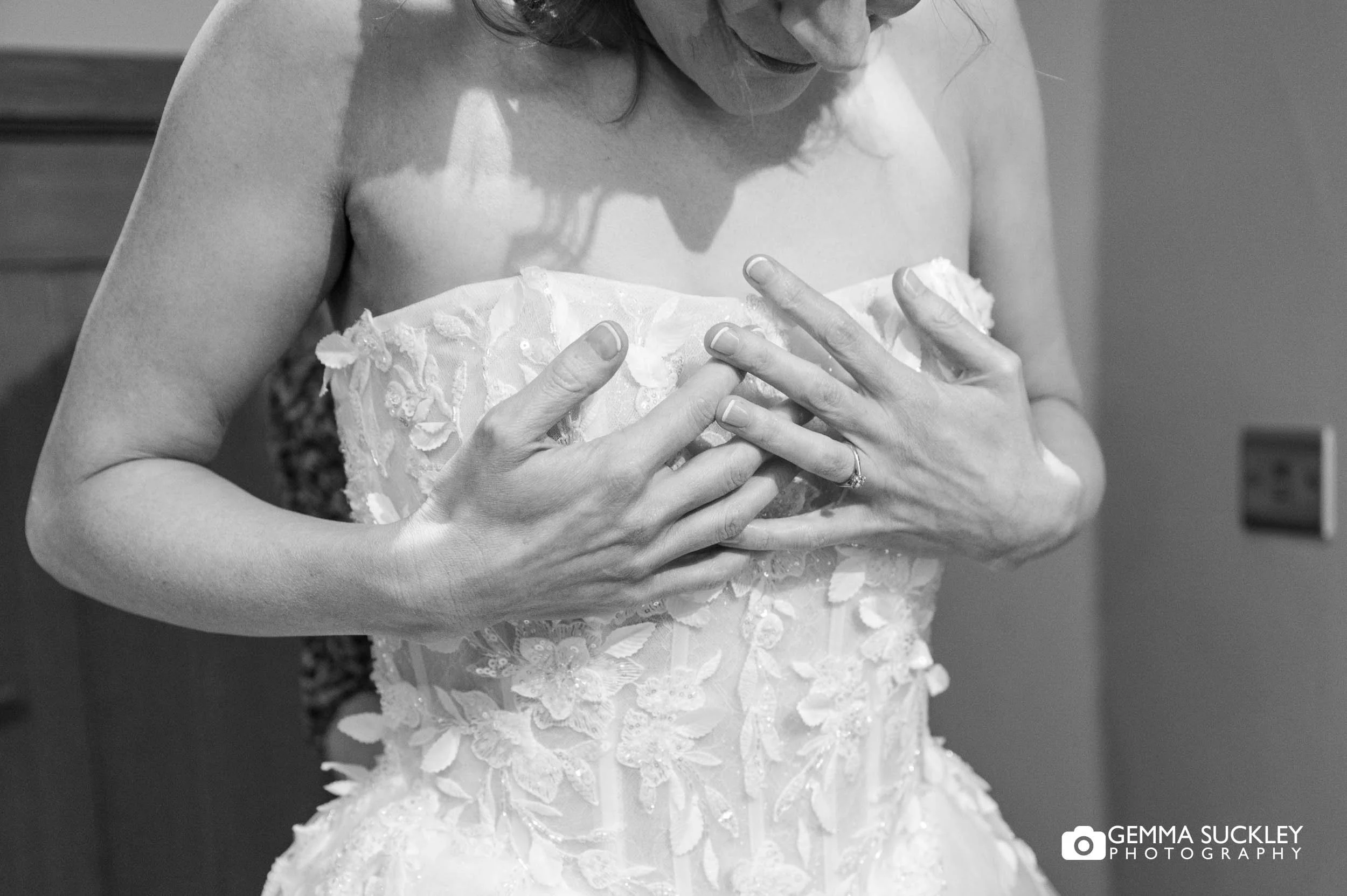Bride getting into wedding dress during morning preparations at The Gamekeeper’s Inn