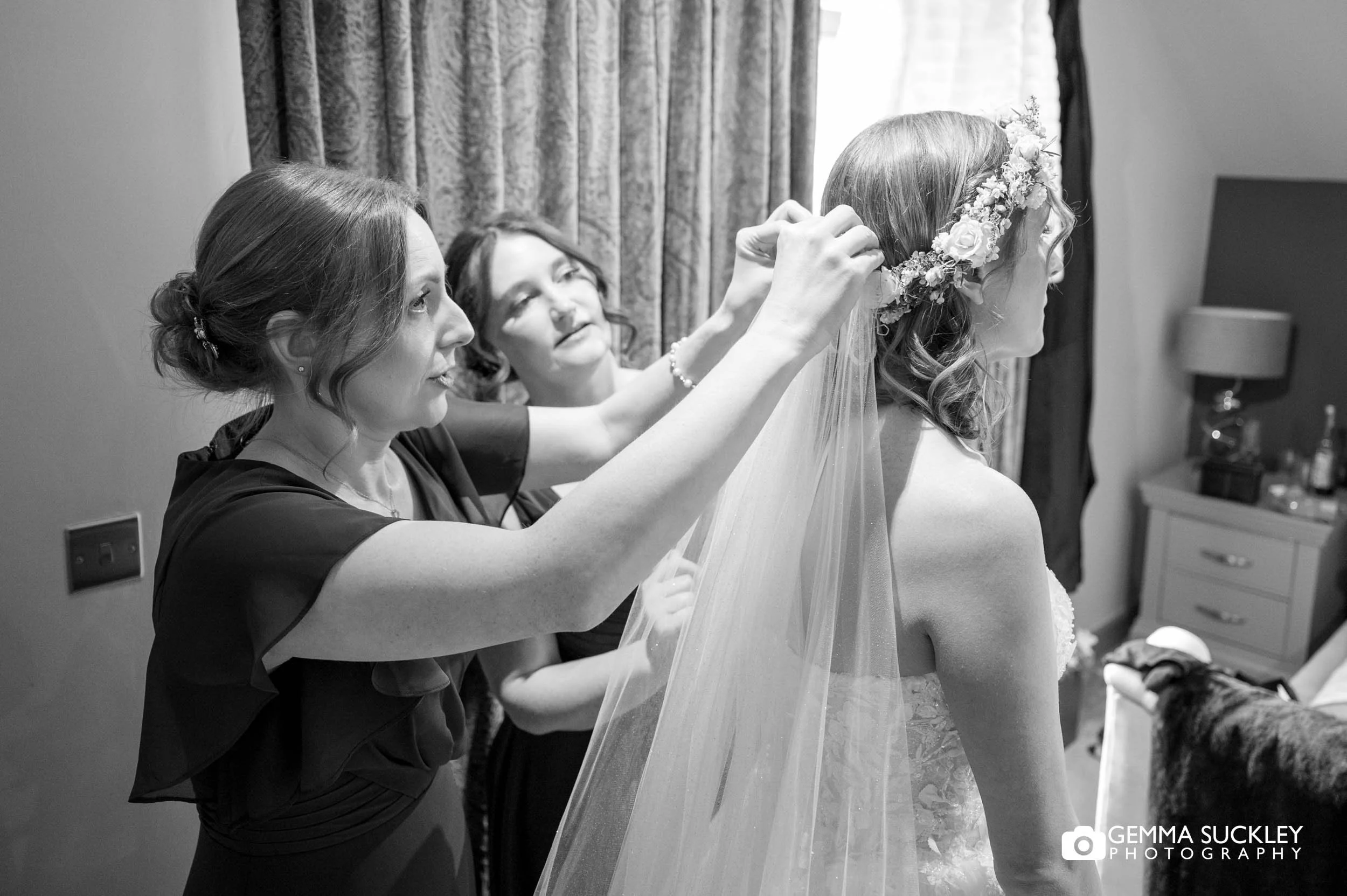 Bridesmaid putting on the veil during morning preparations at The Gamekeeper’s Inn