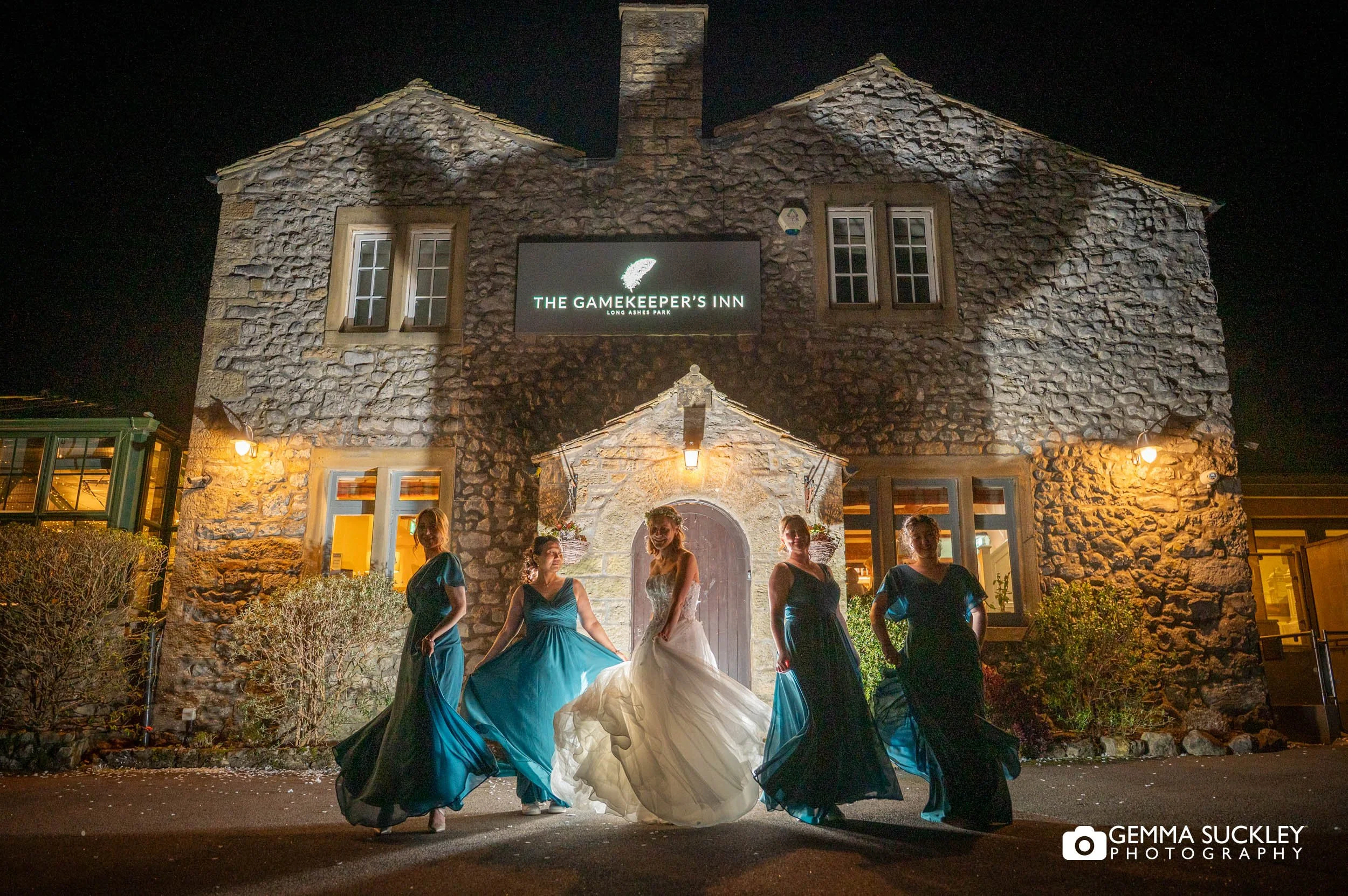 bride and bridesmaids outside the gamekeeper's inn at night