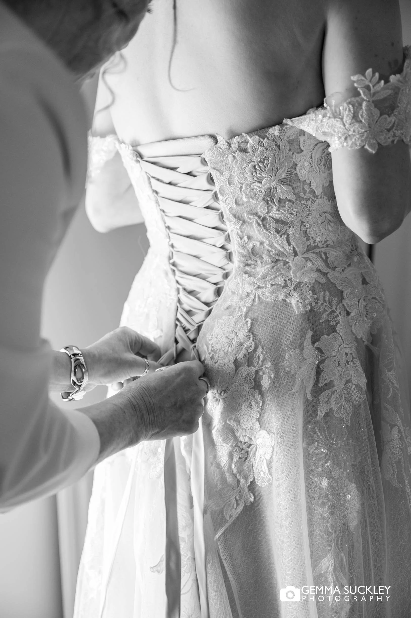 Bride getting into her wedding dress at Falcon Manor