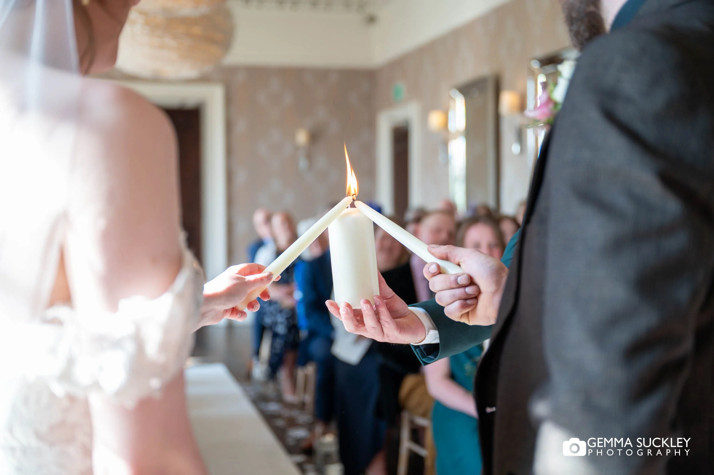 couple lighting candle at the falcon manor wedding ceremony