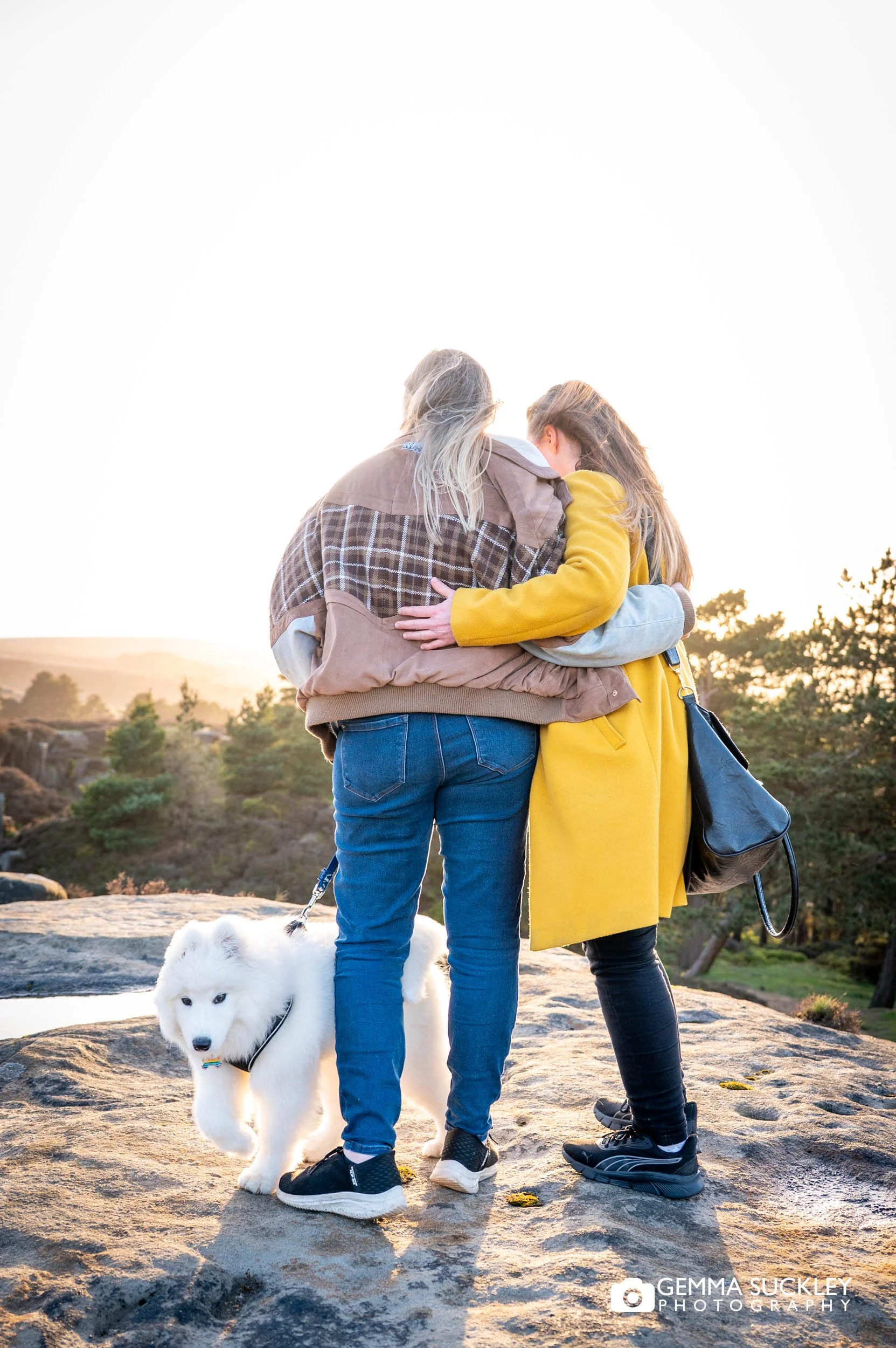 Couple looking at the view at Ilkley Moor at sunset during their Yorkshire pre-wedding photography session.
